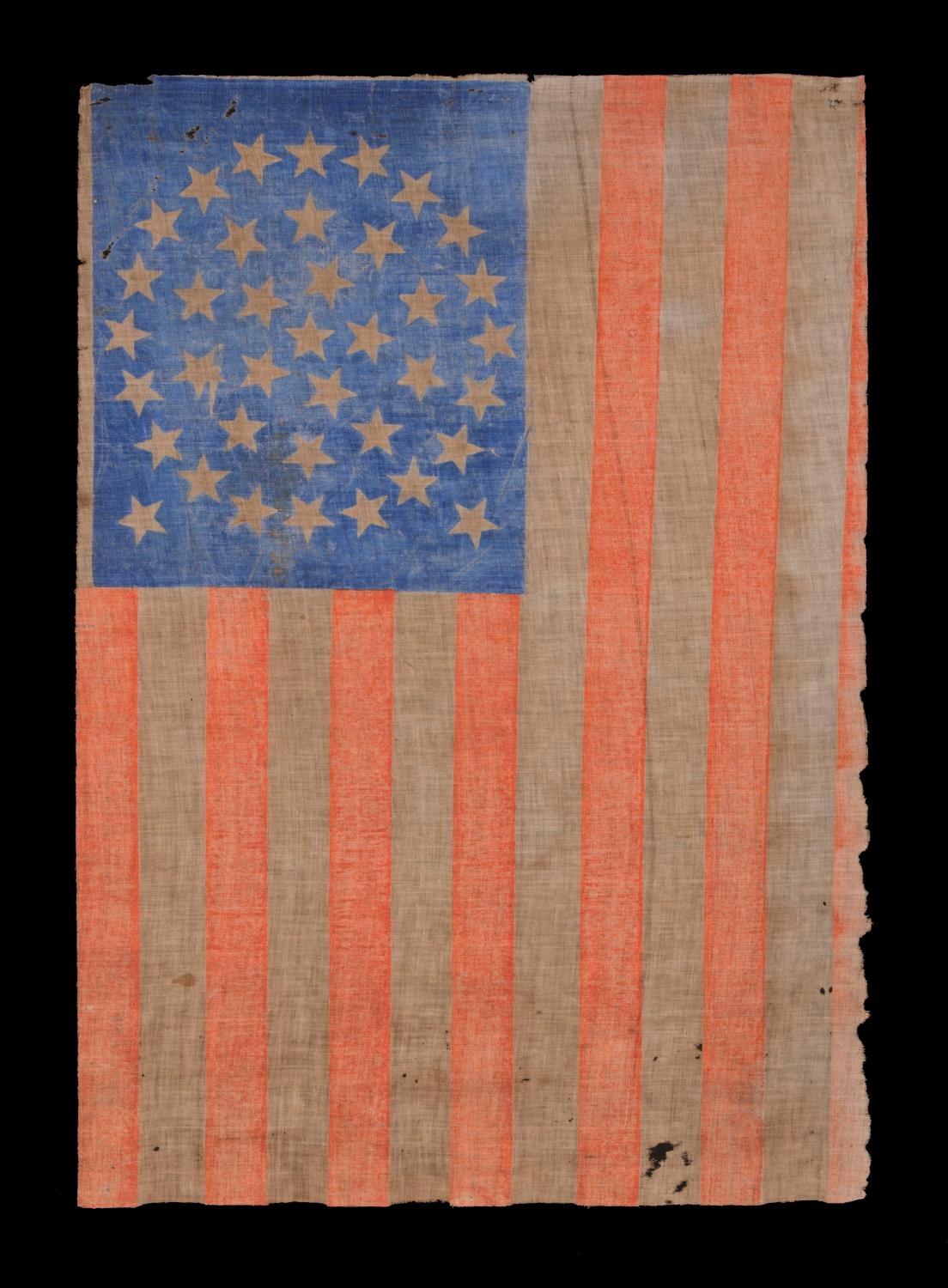 38 STARS IN A MEDALLION CONFIGURATION, WITH 2 OUTLIERS, ON AN ANTIQUE AMERICAN PARADE FLAG WITH RICH, CORNFLOWER BLUE COLORATION AND ENDEARING WEAR, 1876-1889, COLORADO STATEHOOD 

38 star American parade flag, block-printed by hand on coarse,