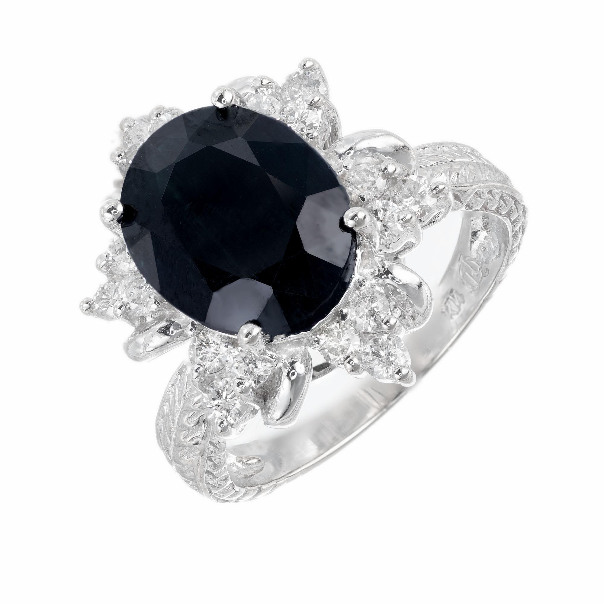 Oval 3.80ct deep blue Sapphire with a halo of 18 full cut diamonds. 14k white gold setting with engraving along the shank. 

1 Oval genuine deep dark blue Sapphire, approx. total weight 3.80cts, 11 x 9mm
18 full cut diamonds, approx. total weight