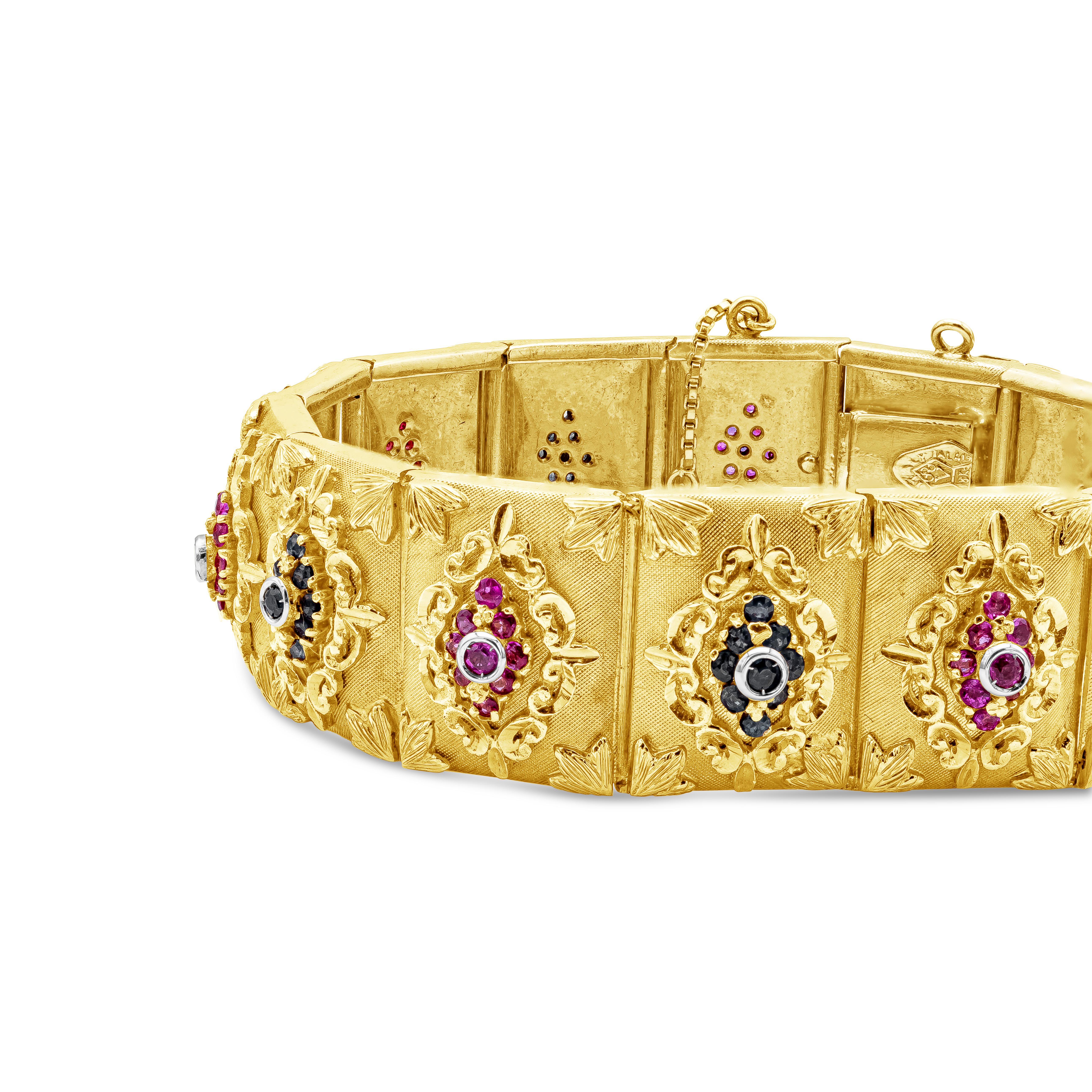 Ein wunderschönes, modisches, handgefertigtes Design-Armband aus 18K Gelbgold mit einem Gewicht von 55 Gramm. Akzentuiert mit rotem Rubin und blauem Saphir mit einem Gesamtgewicht von 3,80 Karat, umhüllt von geprägtem Ornamentdesign. 

Roman Malakov
