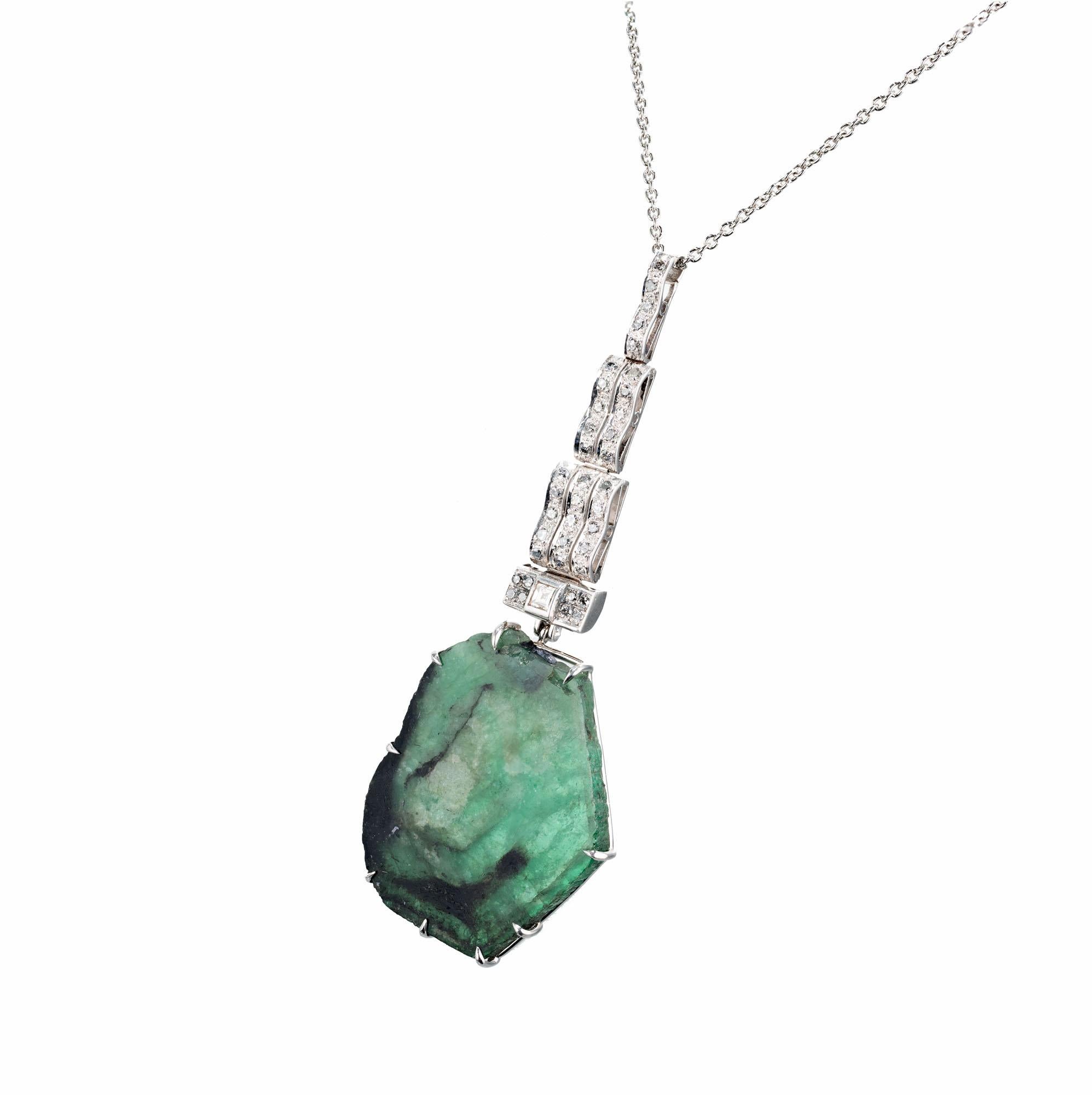 Art Deco Translucent natural Emerald crystal slice dangling from a hinged wavy handmade Platinum top. Accented with 44 round diamonds on a platinum chain. 

1 Natural untreated Emerald crystal slice, approx. total weight 38.00cts
44 single cut
