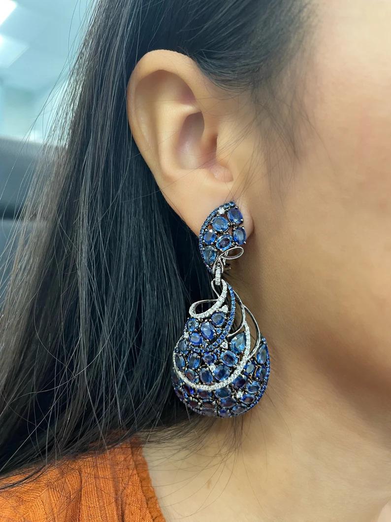 Stunning natural sapphire earrings. The earrings feature 72 natural sapphires weighing 38.03 ct. and 118 round diamonds weighing 1.64 ct. set in 18k white gold. The diamonds are F/G in color and VS2/SI1 in clarity. A gorgeous addition to any
