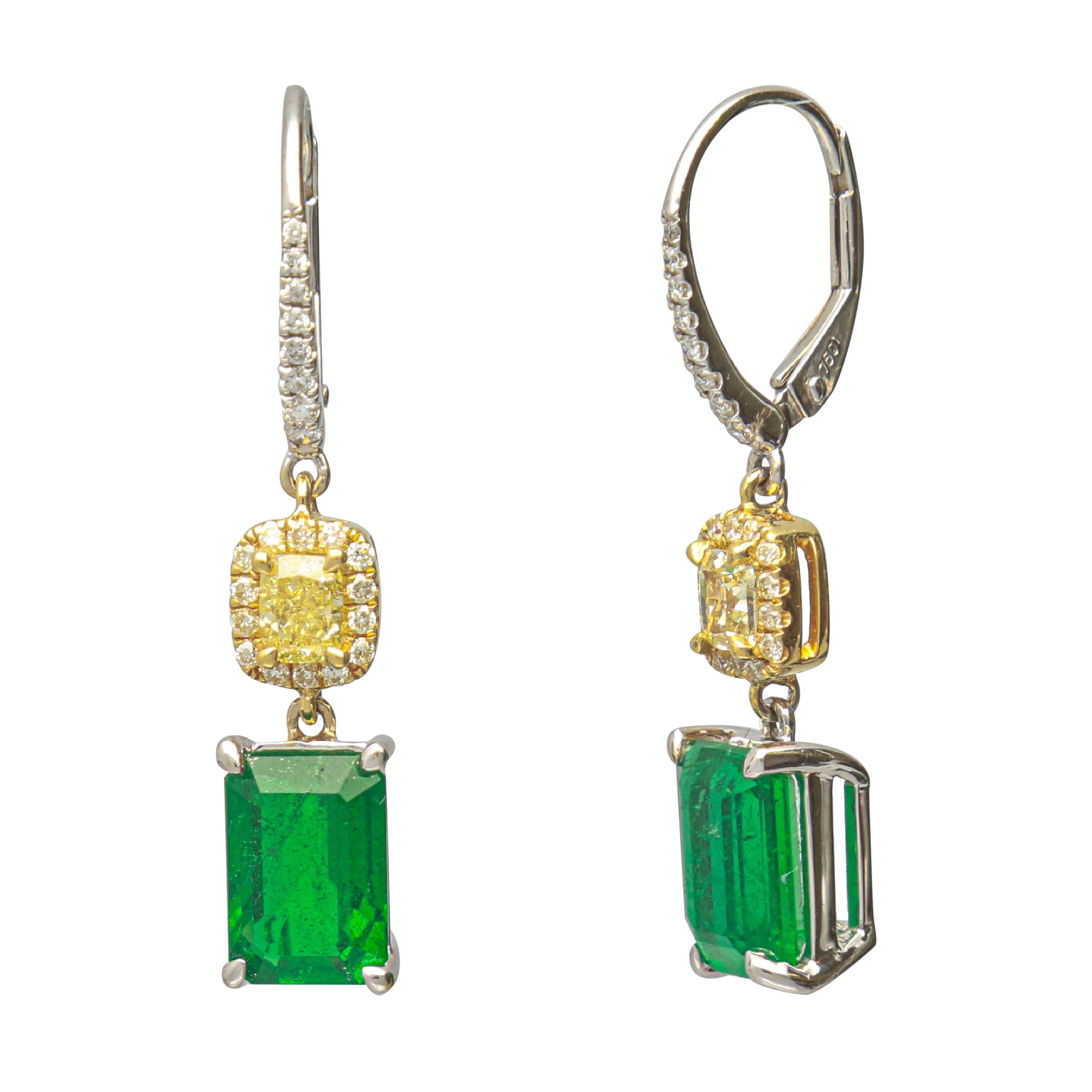 This one of a kind Lever back Earring is crafted in 18-karat White and Yellow Gold and features 2 Emerald cut Emeralds 3.81 Carat, 2 Yellow Diamond 0.60 Carat, 28 Yellow Diamond 0.17 Carat & 16 Brilliant cut Round Diamonds 0.11 Carat. This Earring