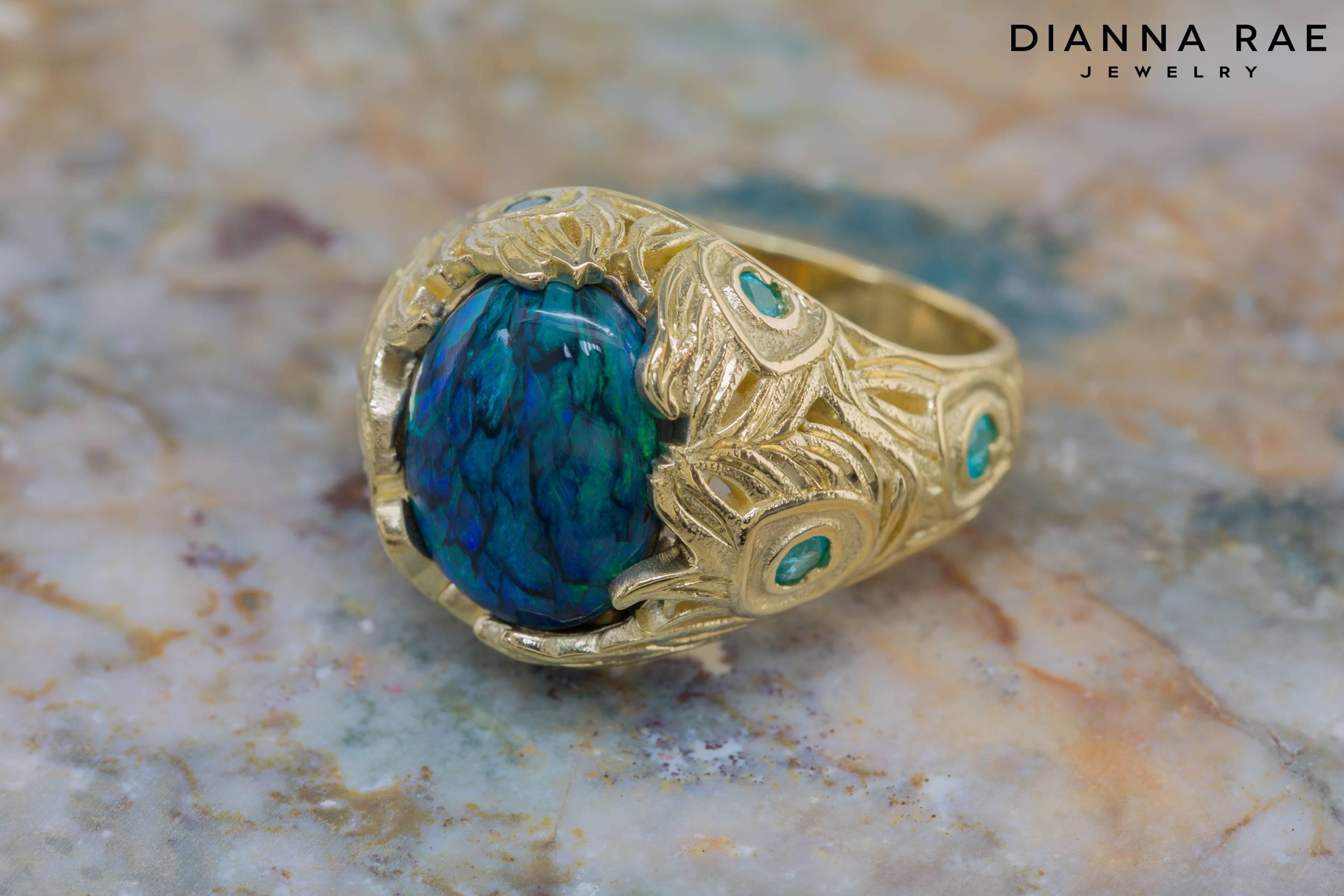 3.82 Carat Black Opal with Paraiba Tourmaline Peacock Ring in 18K Yellow Gold

Truly inspired by nature, this captivating rare 3.82 carat black opal has a natural play of colors that resemble beautiful blue and green peacock feathers. To perfectly