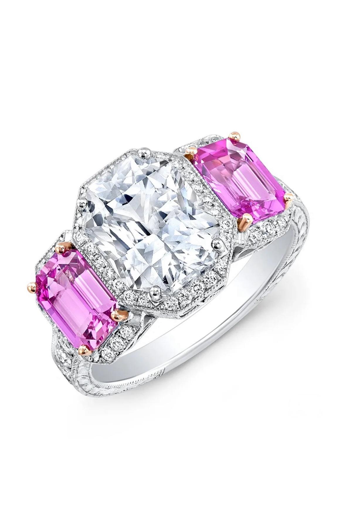 A radiant-cut 3.82-carat, white sapphire makes a dazzling display with two pink sapphires 2.25cts, and round diamonds totaling 0.60cts in 18K white gold. GIA certified.