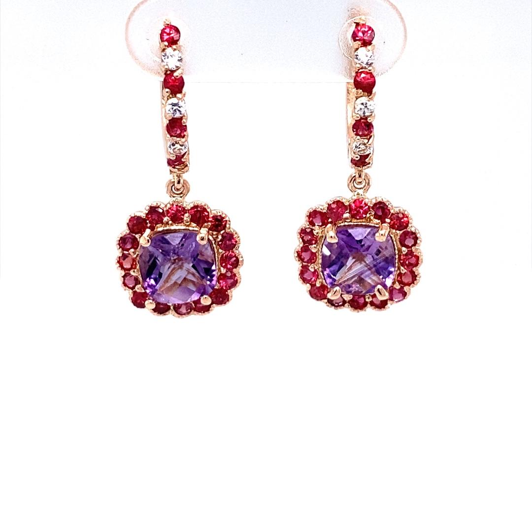 These cute and dainty Earrings have 2 Cushion Cut Amethysts that weigh 2.27 Carats and are embellished with 46 Round Cut Red and White Sapphires that weigh 1.56 Carats. The Total Carat weight of the Earrings are 3.83 Carats. 
The Earrings are about