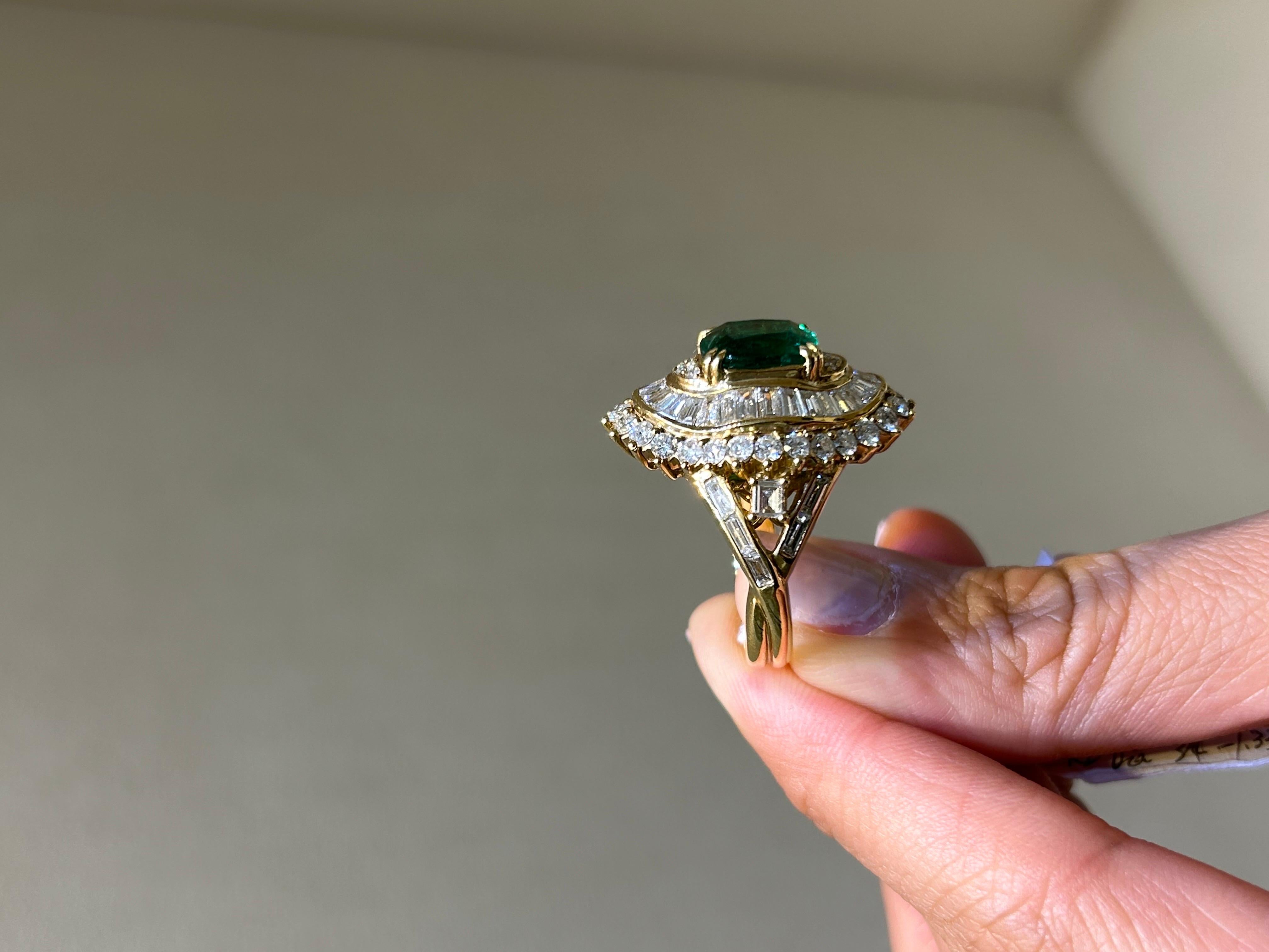 An antique, art-deco looking, 3.83 carat Zambian Emerald and 3.23 carat White Diamond cocktail ring, set in solid 18K Yellow Gold. The ring is made is Switzerland. Currently sized at US8, can be resized. 
We provide free shipping, and accept