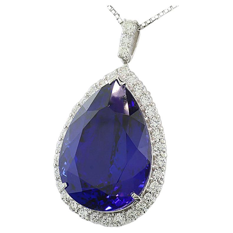 a real jewel: a tanzanite approx. 38.31 carat, deep blue with beautiful purple overtone, uniform color distribution, very good color saturation, vivid brilliance, eye-clean, pear cut. Surrounded by brilliant cut diamonds, the eye side set with