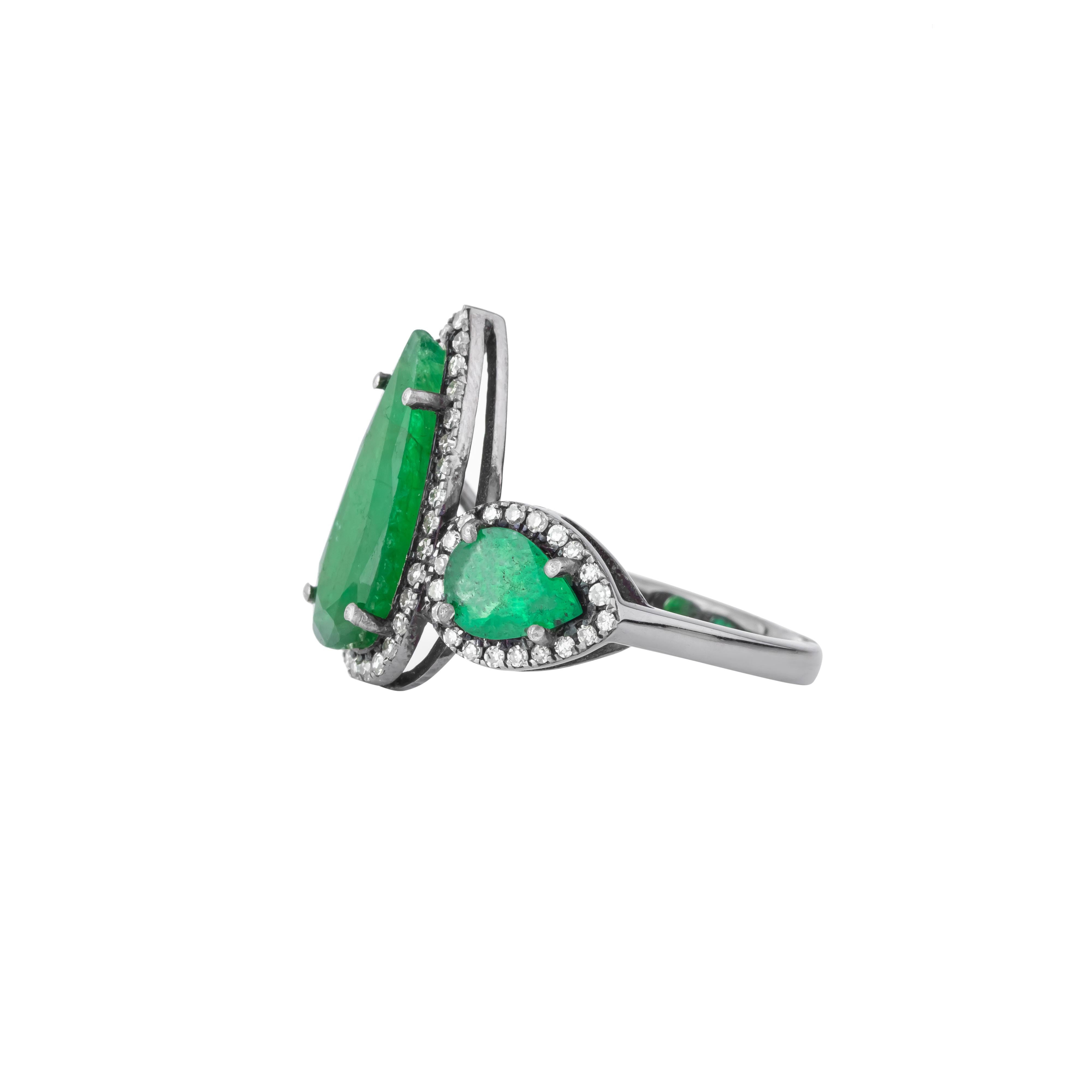 Un'incredibile miscela di lusso ed eleganza, l'anello con tre pietre di diamante e smeraldo da 3,84 carati cattura l'essenza della raffinatezza senza tempo. Il centro è un affascinante smeraldo, che emana una vivida tonalità di verde che simboleggia