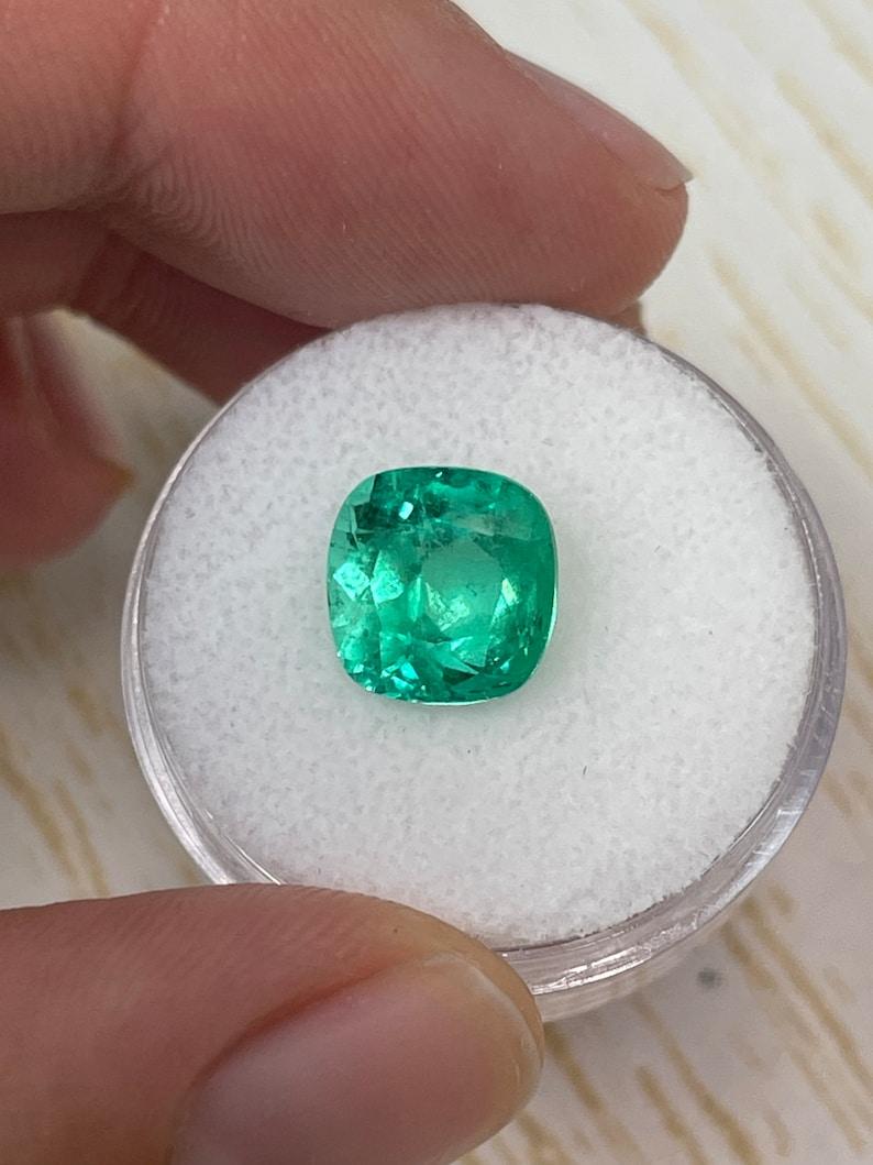 Stone: Emerald
Weight: 3.85-carats
Shape: Cushion Cut
Clarity: Transparent
Luster: Very Good
Color: Yellowish Green
Measurements: 9.48mm x 9.24mm x 6.97mm
Geographic Origin: Colombia
Treatment: Natural, Oiling

Comments: Due to their growth