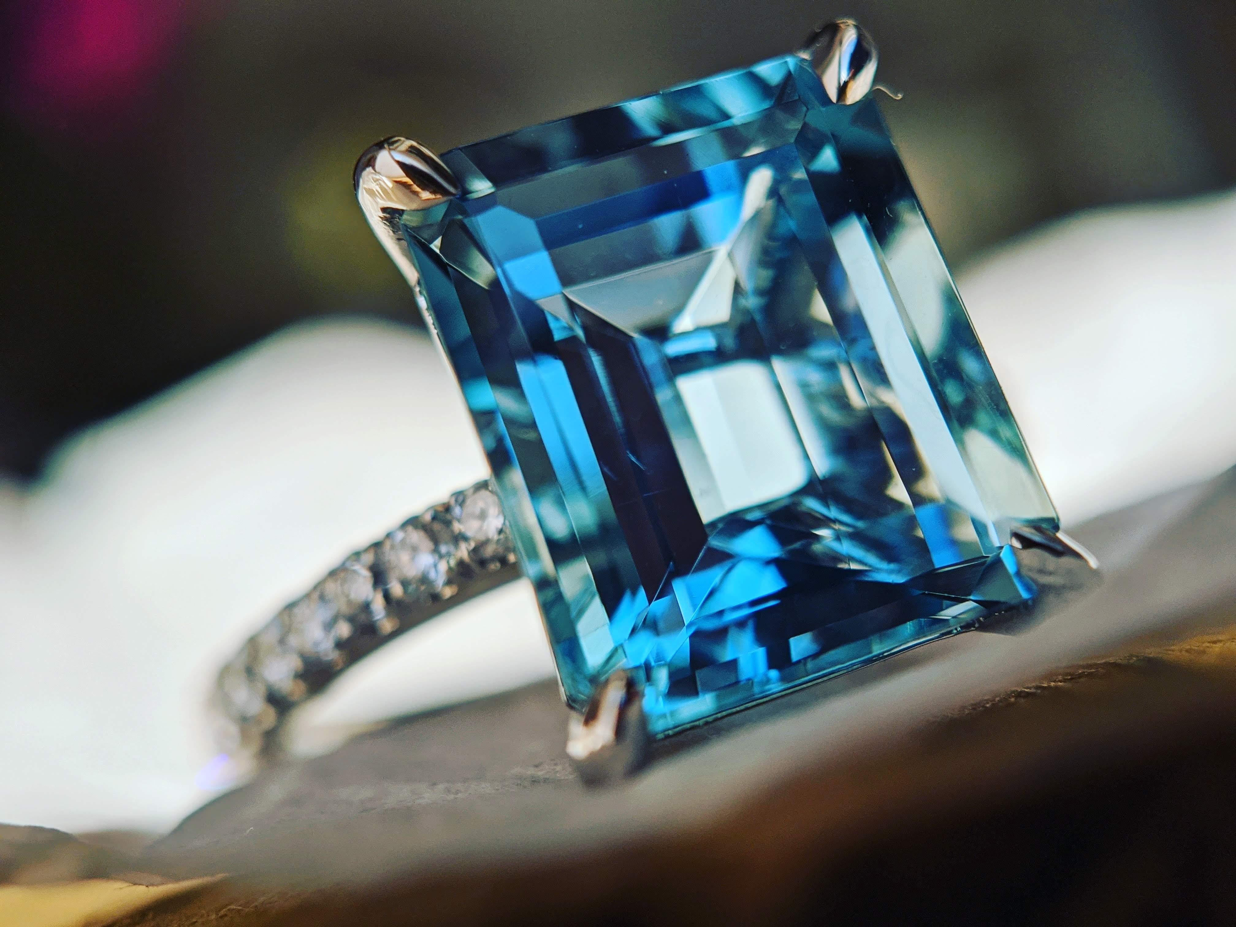 An exquisite 3.85 carat Aquamarine, emerald cut, very high quality color, eye clean gem, ethically mined and sourced, accompanied a pave' of bright diamonds of approximately  total carat weight of 0.38 carat, set in an hand crafted, delicate and
