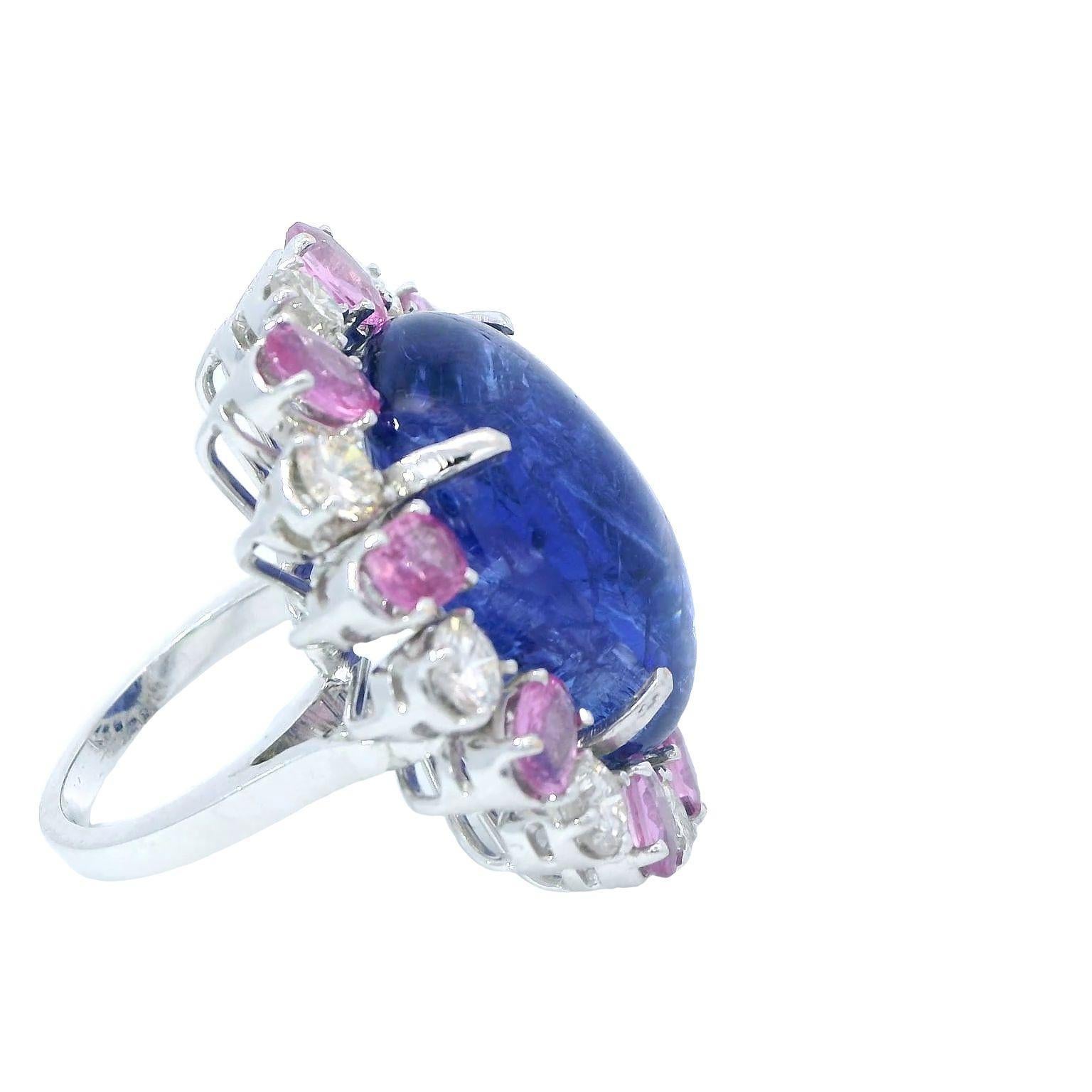 The ring showcases a captivating centerpiece in the form of a cabochon-cut Tanzanite, weighing an impressive 38.35 carats. The Tanzanite stone exhibits a smooth, rounded surface that enhances its natural beauty and color. Surrounding the Tanzanite