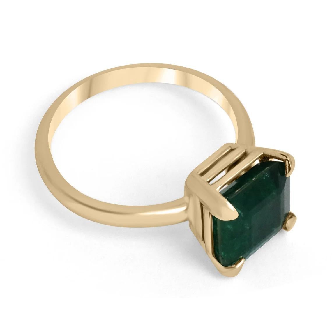 Displayed is a classic emerald solitaire Asscher-cut engagement ring/right-hand ring in 18K yellow gold. This gorgeous solitaire ring carries a full 3.85-carat emerald in a four-prong setting. Fully faceted, this gemstone showcases excellent shine.