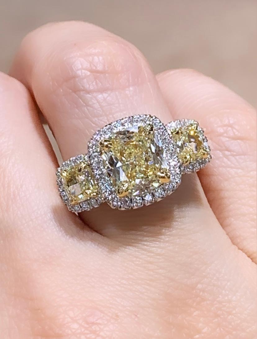 You will adore our Cushion Cut Three Stone Diamond Ring because of its fantastic sparkle and light yellow shine! Made for a true Princess you will adore the unique twist to the classic three-stone diamond engagement ring. Even more, sparkle is added