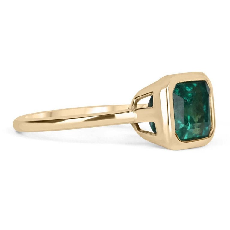 Displayed is a vibrant-green emerald, solitaire, emerald-cut bezel ring in 14K yellow gold. This gorgeous solitaire ring carries a full 3.85-carat emerald in a sleek bezel setting. This is an ideal engagement ring or right-hand ring!

Setting Style: