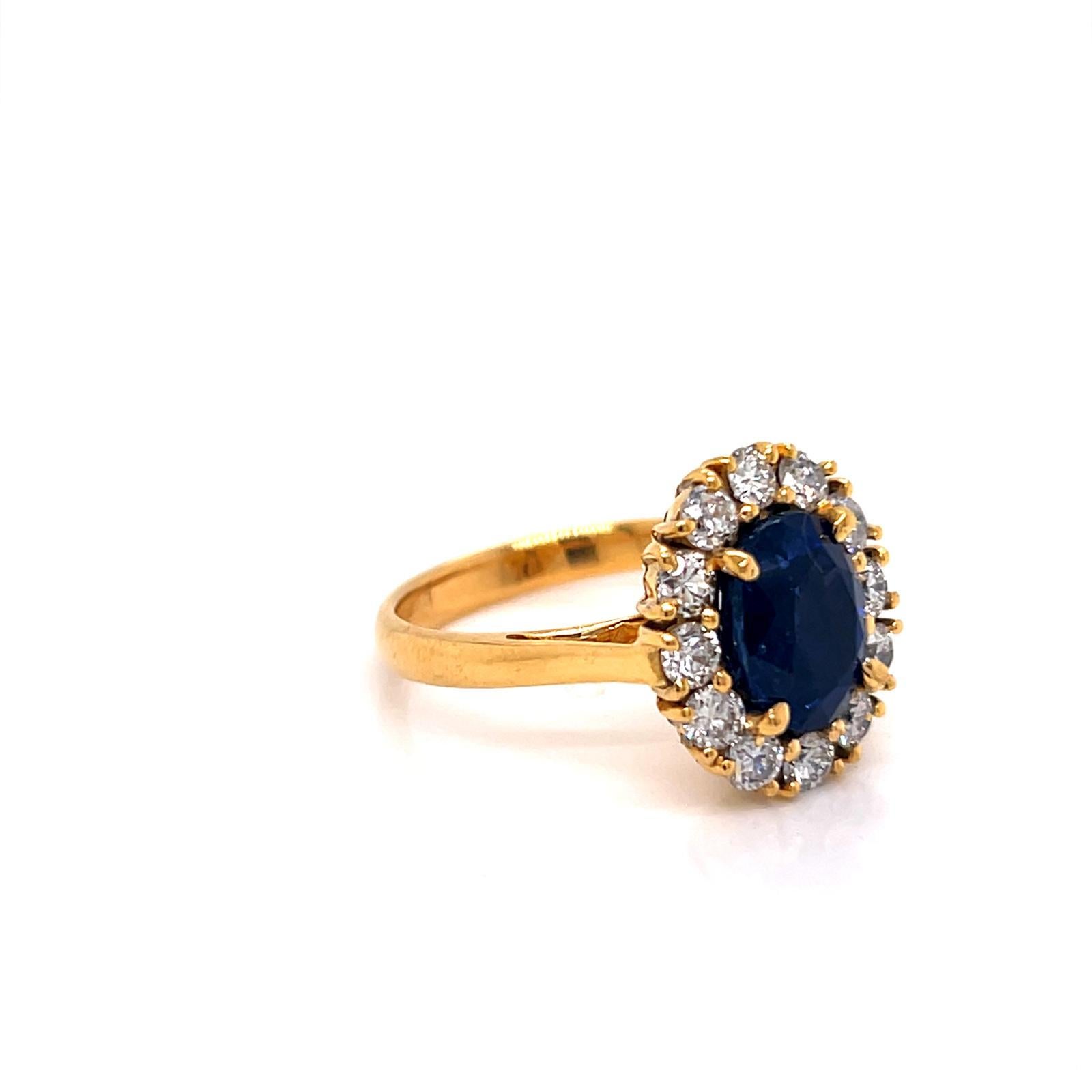 3.86 Carat Oval-cut Blue Sapphire and Round Brilliant  Diamond Cluster Ring set in 18K Yellow Gold 

A true celebration of timeless elegance and regal allure, this striking ring showcases a captivating 3.86 carat Oval-cut Blue Sapphire. Radiating