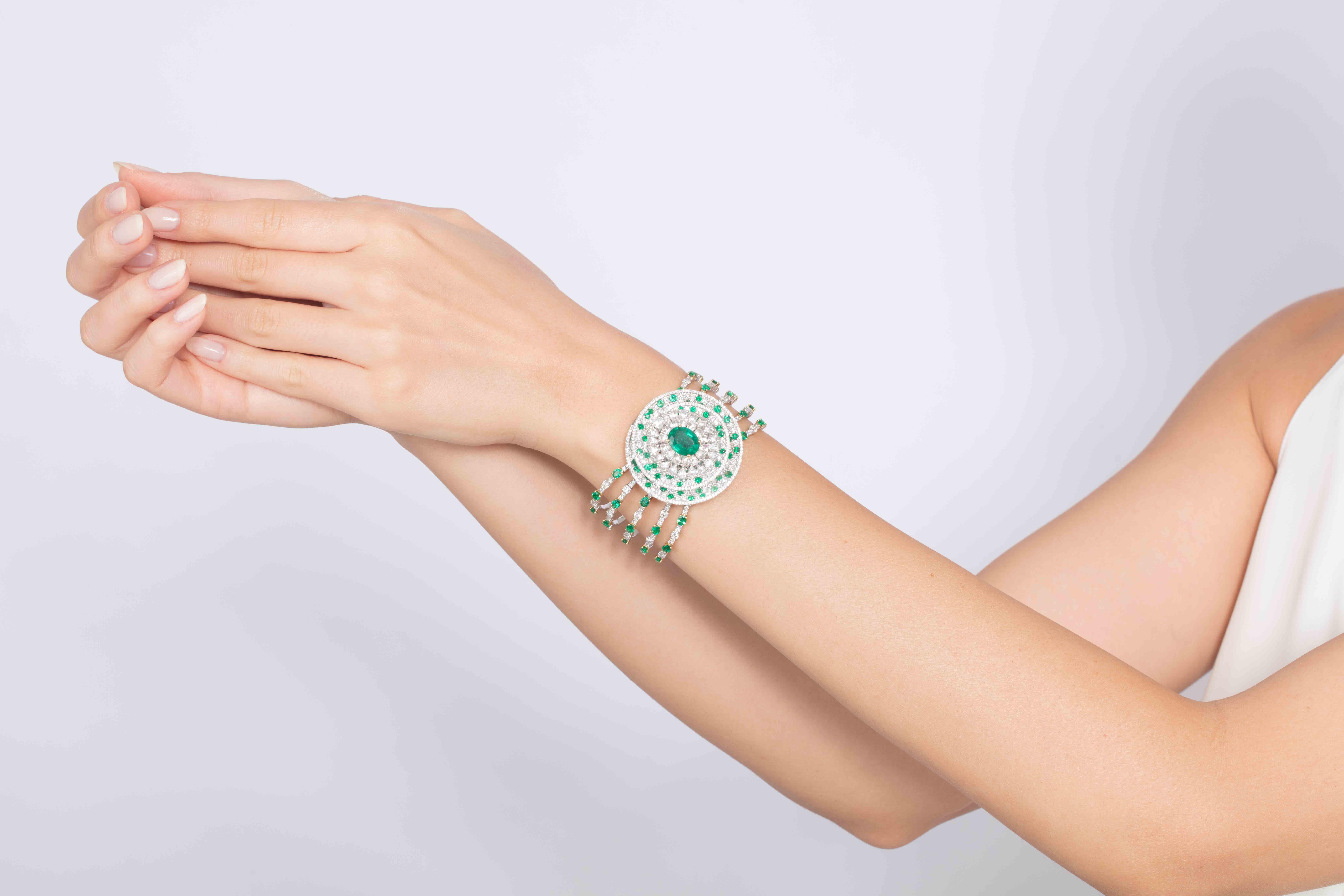 Every angle of Butani's cuff showcases the brand's attention to detail.  This stunning cuff bangle is handmade from 18 karat white and yellow gold and is centered with a striking 3.86 carat oval emerald illuminated by rose-cut and brilliant-cut
