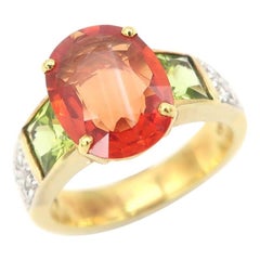 3.86 Carat Oval Orange Sapphire Diamond Pavé Ring Flanked with Square Peridots