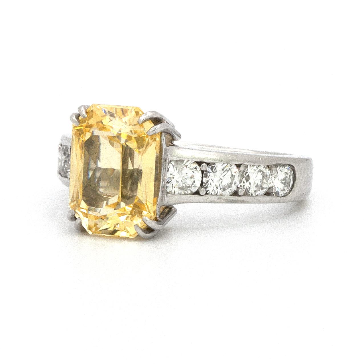 Contemporary platinum ring with a 3.86 carat yellow sapphire that is set in a split prong basket with 8 round brilliant cut, clean white diamonds, that weigh 1.10 carats in total. 
Free resizing