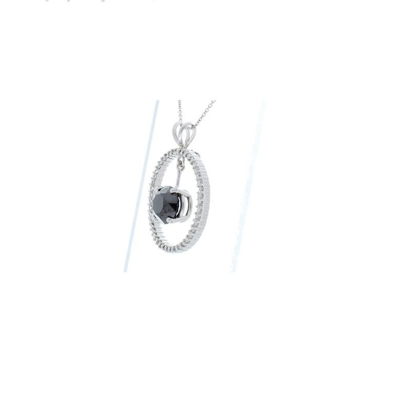 This necklace is total diamond suspension. An 8.87 carat brilliant cut black diamond floats in the center of a glowing 0.67 carat circle of 45 brilliant cut diamonds, hung from a delicate 14 K white gold setting with a classic split bail. The