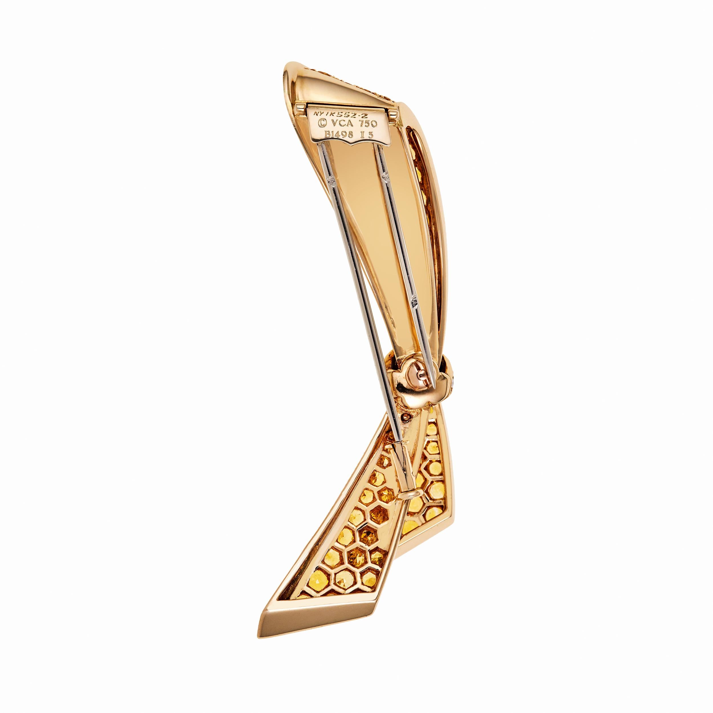 Van Cleef & Arpels Clip in 18 Karat Yellow Gold and Platinum.  Signed Piece.  Holds 3.69 Carats of Yellow Sapphires and 0.20 Carats of Diamonds in the Platinum band that pinches the Yellow Ribbon together.  Perfect condition.  Clip measures 2 1/2