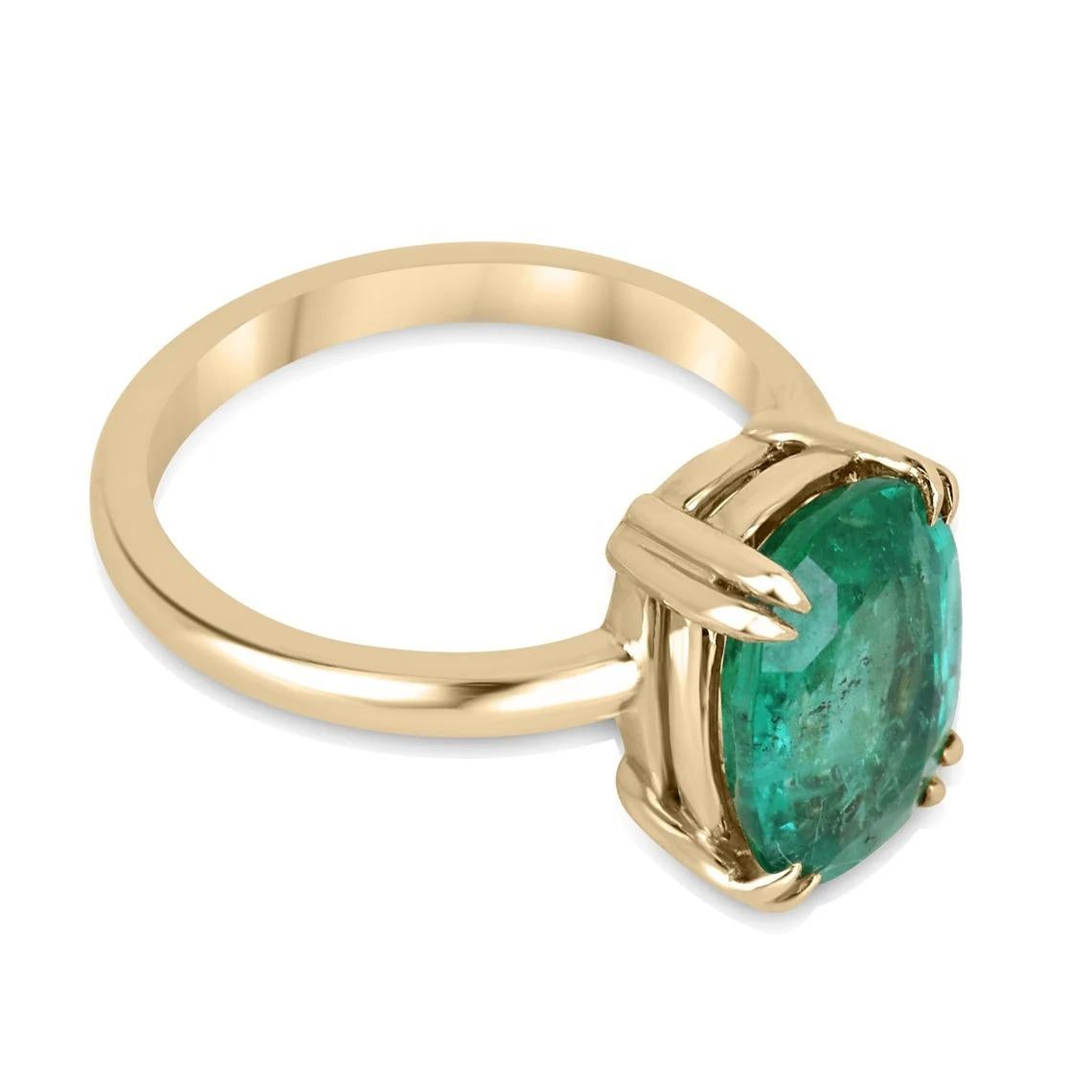 This stunning solitaire ring features a natural 3.89-carat elongated cushion cut emerald that displays a vibrant, medium-green color and very good clarity, adding to its allure. The emerald is set in an elegant double-prong setting crafted from 14k