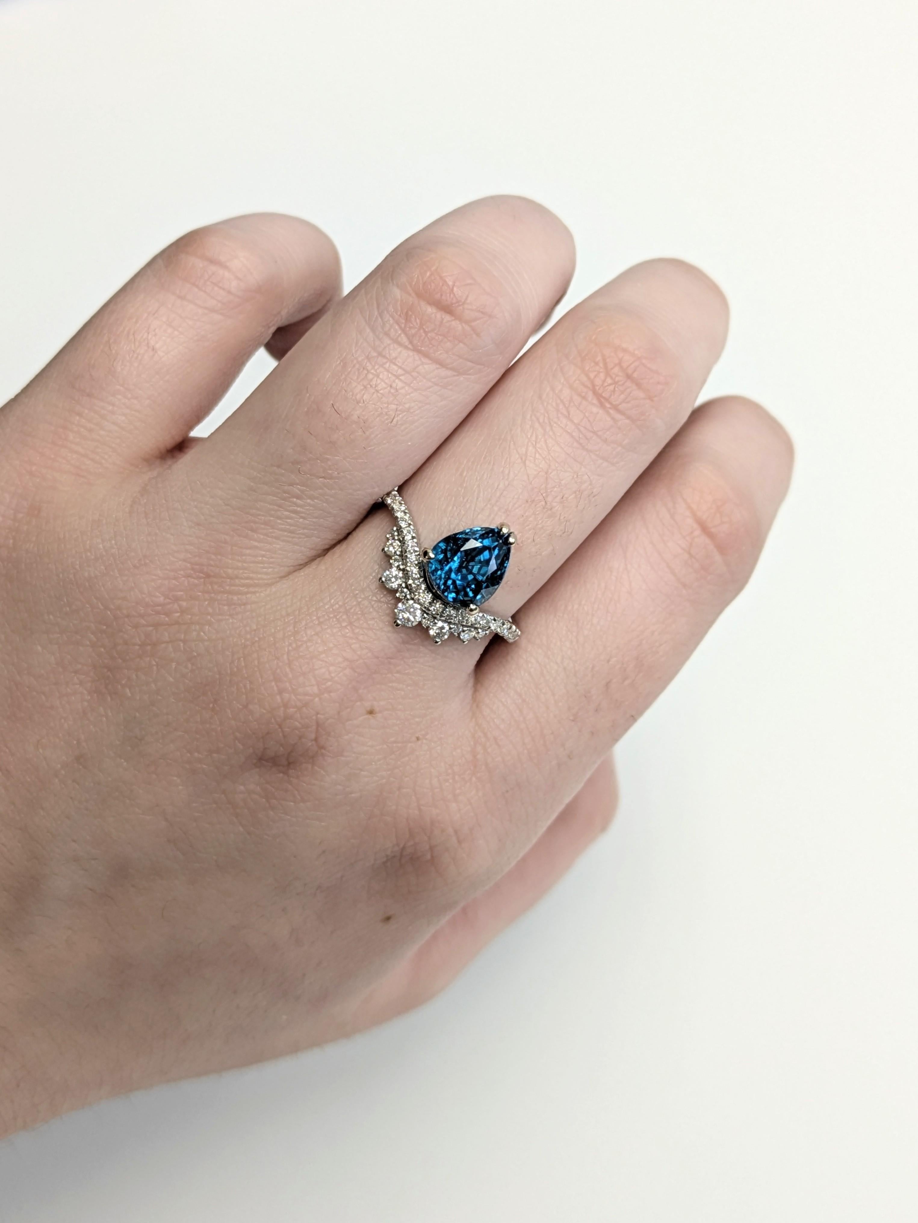 Cette bague en zircon bleu en forme de poire de 3,78ct est un véritable joyau couronné d'une tige en diamant de style tiare. Fabriquée en or massif 14 carats et rehaussée de diamants naturels extraits de la terre, cette bague est digne d'un roi et