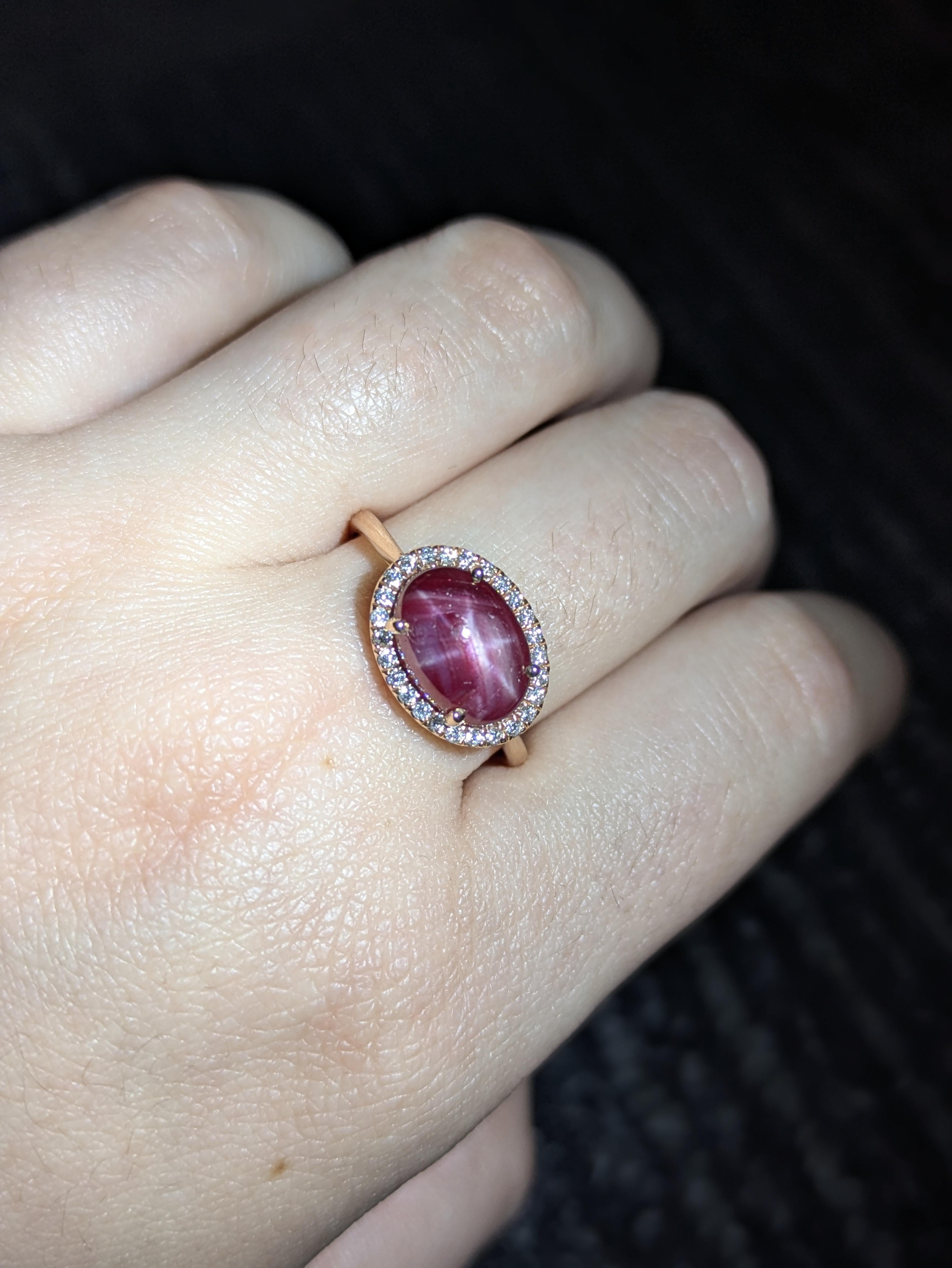 Elegante anello in oro massiccio 14k con un rubino ovale a stella naturale di 11x7,6 mm, circondato da una scintillante aureola di diamanti autentici. Un pezzo senza tempo che unisce lusso e raffinatezza.

