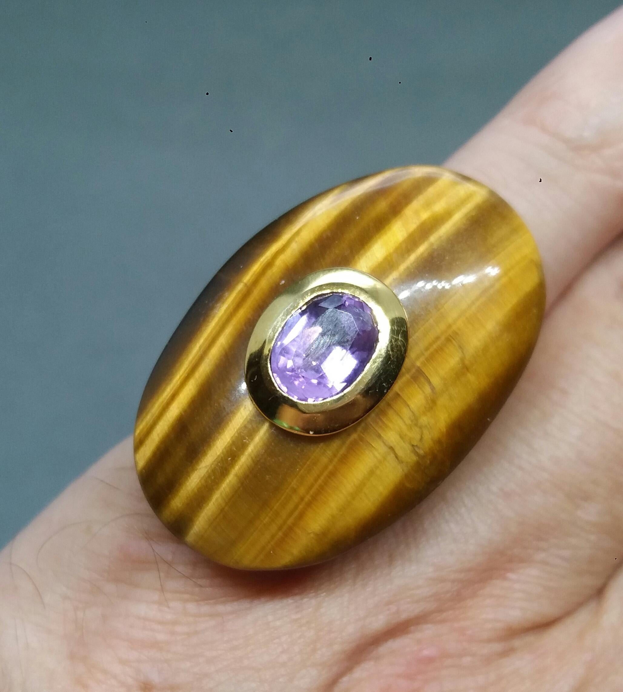 Unique ring with a Oval Shape Tiger Eye ,measuring 38 mm. x 25 mm x 6mm. and weighing 51 Carats with a nice Oval Faceted Amethyst measuring 8 mm x 10 mm set in 14 kt yellow gold...Ring shank is also in 14 kt  solid yellow gold now in american size #