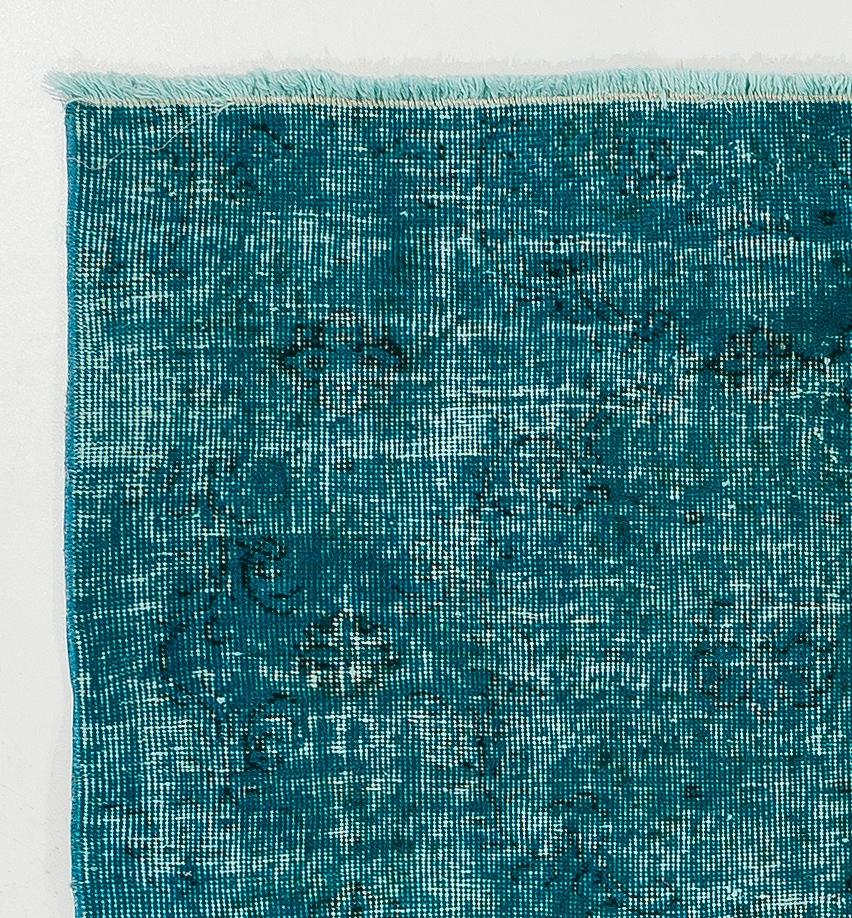 A vintage hand-knotted Turkish accent rug, over-dyed in teal blue, great for bringing a touch of color to modern interiors. It has finely hand-knotted distressed low wool pile on cotton foundation. It is professionally washed, in good condition with