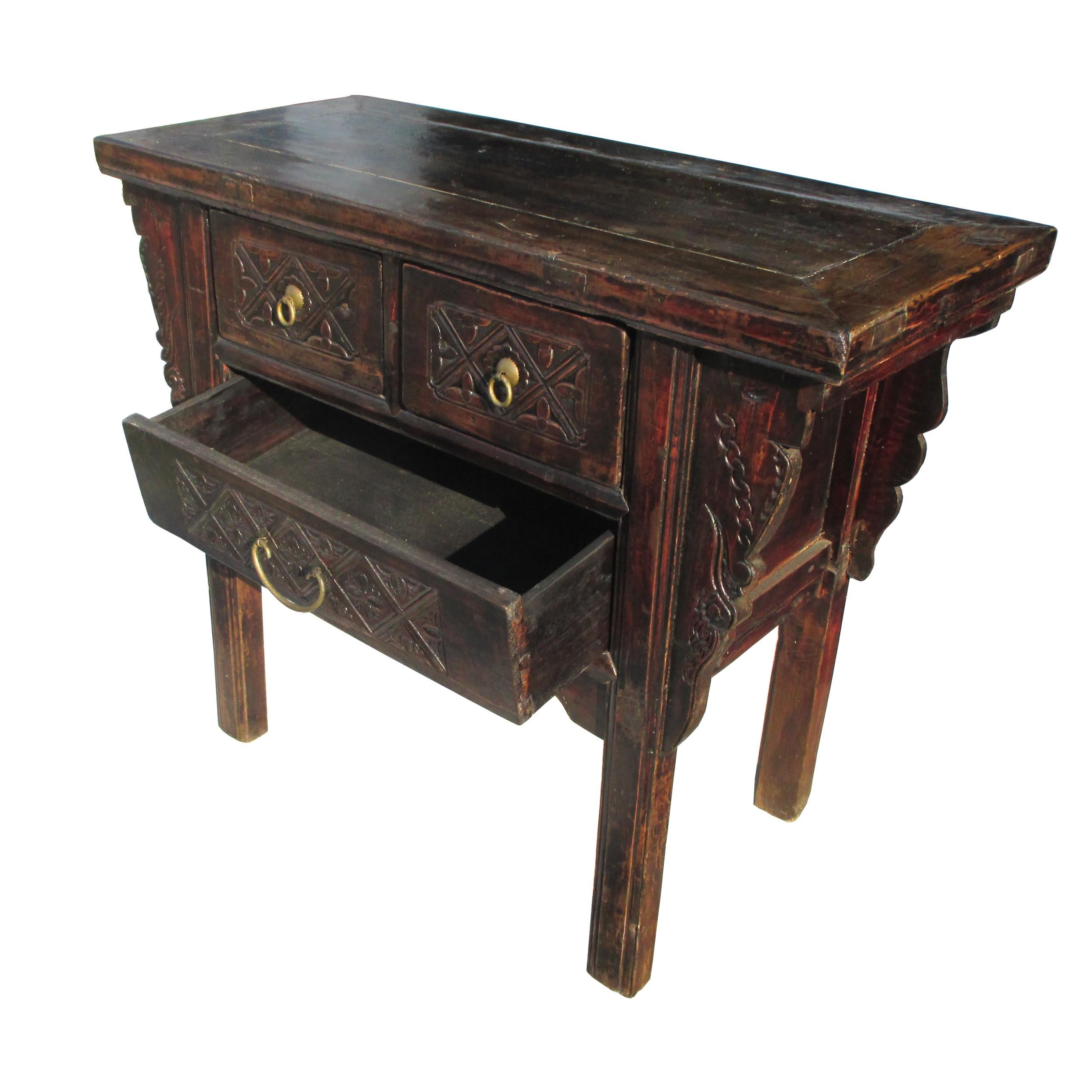 19th century Qing Dynasty alter console table

Beautifully aged patina with 3 drawers and original brass pulls. 
Cabinet is accented with scrolled motifs. Straight legs with carved apron. 
    