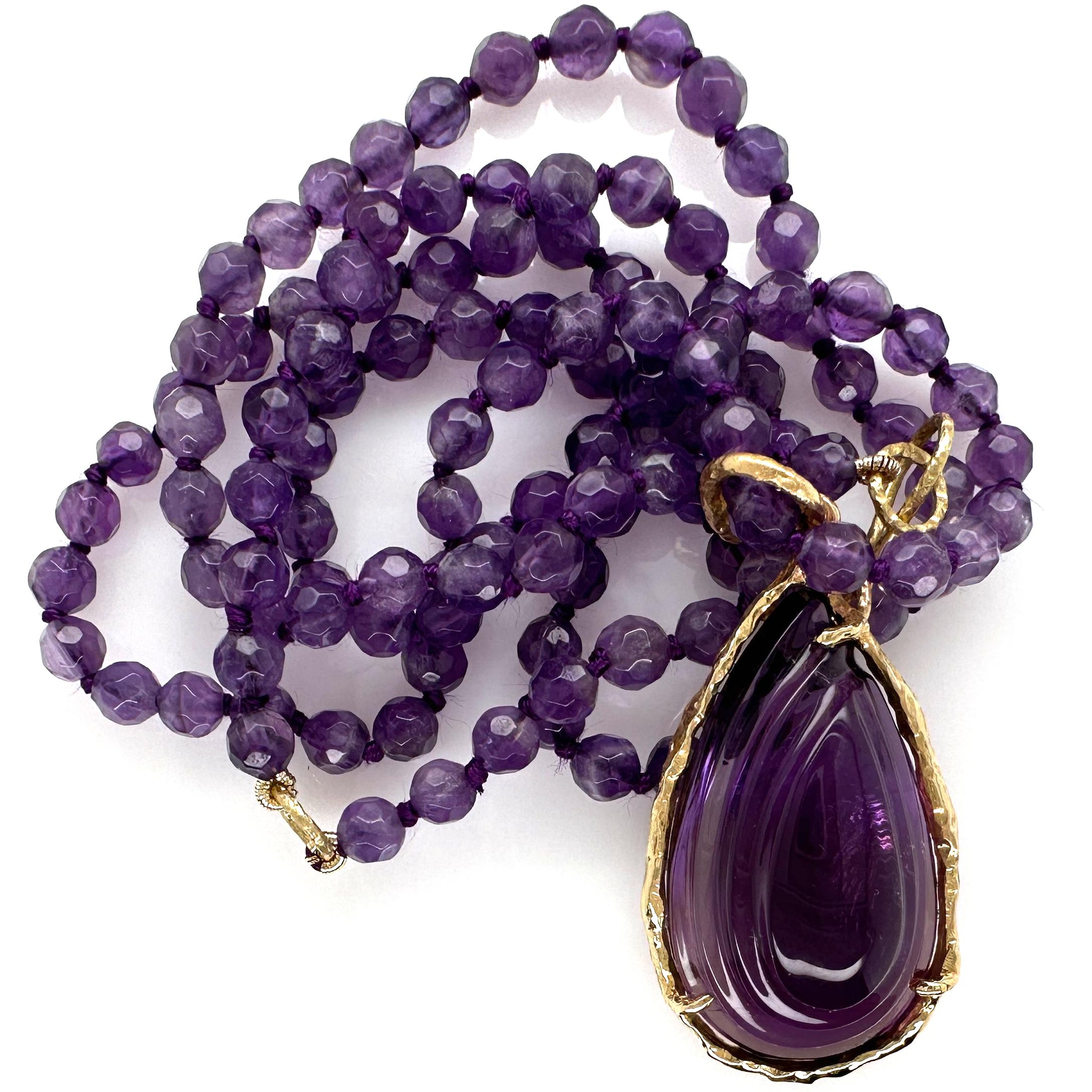This graceful carved amethyst teardrop is part of a trio of amethyst drops purchased by Eytan Brandes at a trade show several years ago.  Opting to break up the set, Eytan made the two smaller drops into dressy earrings accented with diamonds.  (You