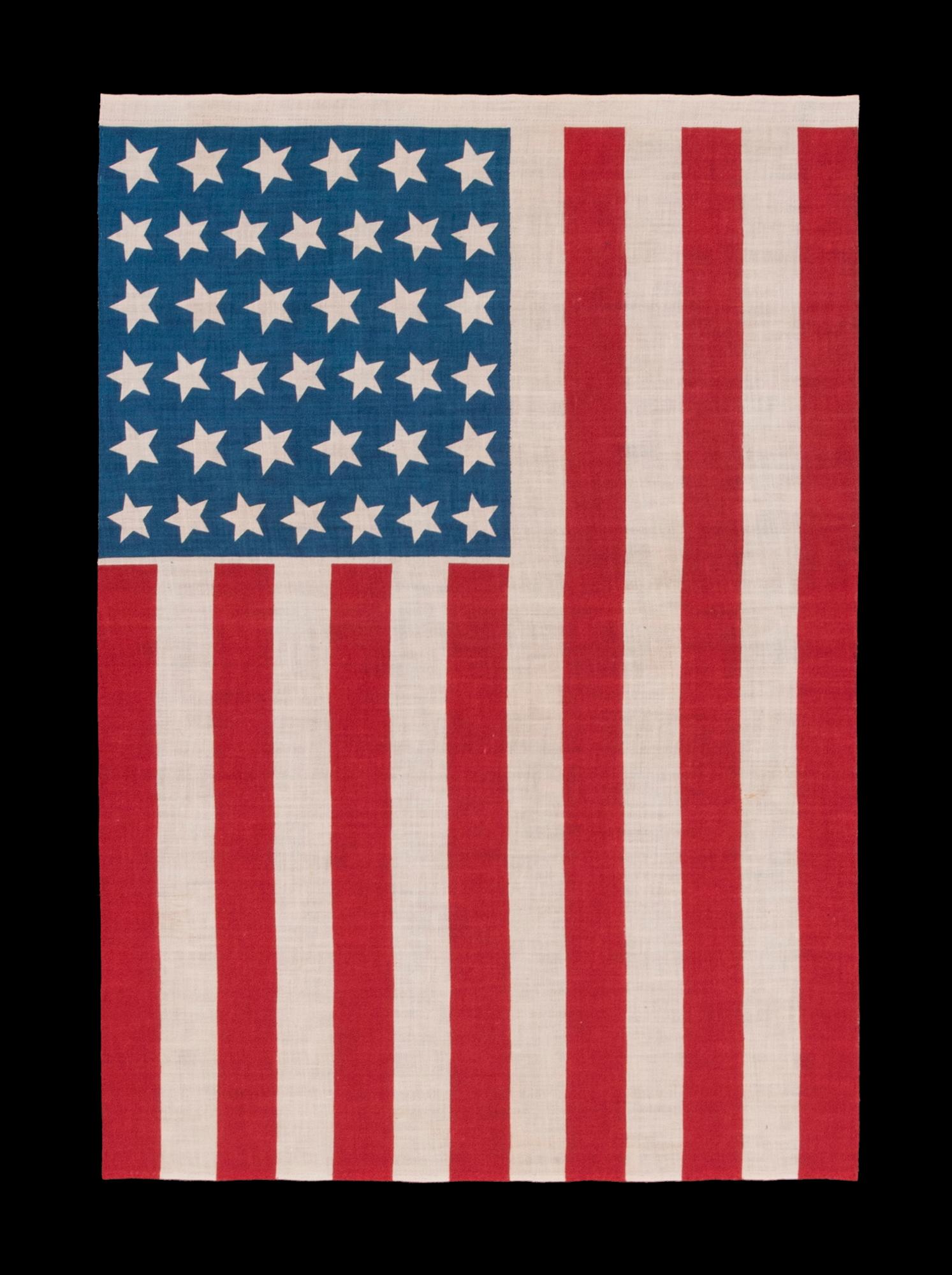 39 STARS IN TWO SIZES, ALTERNATING FROM ONE COLUMN TO THE NEXT, ON AN ANTIQUE AMERICAN PARADE FLAG DATING TO THE 1876 CENTENNIAL, NEVER AN OFFICIAL STAR COUNT, REFLECTS THE ANTICIPATED ARRIVAL OF COLORADO AND THE DAKOTA TERRITORY

39 star American