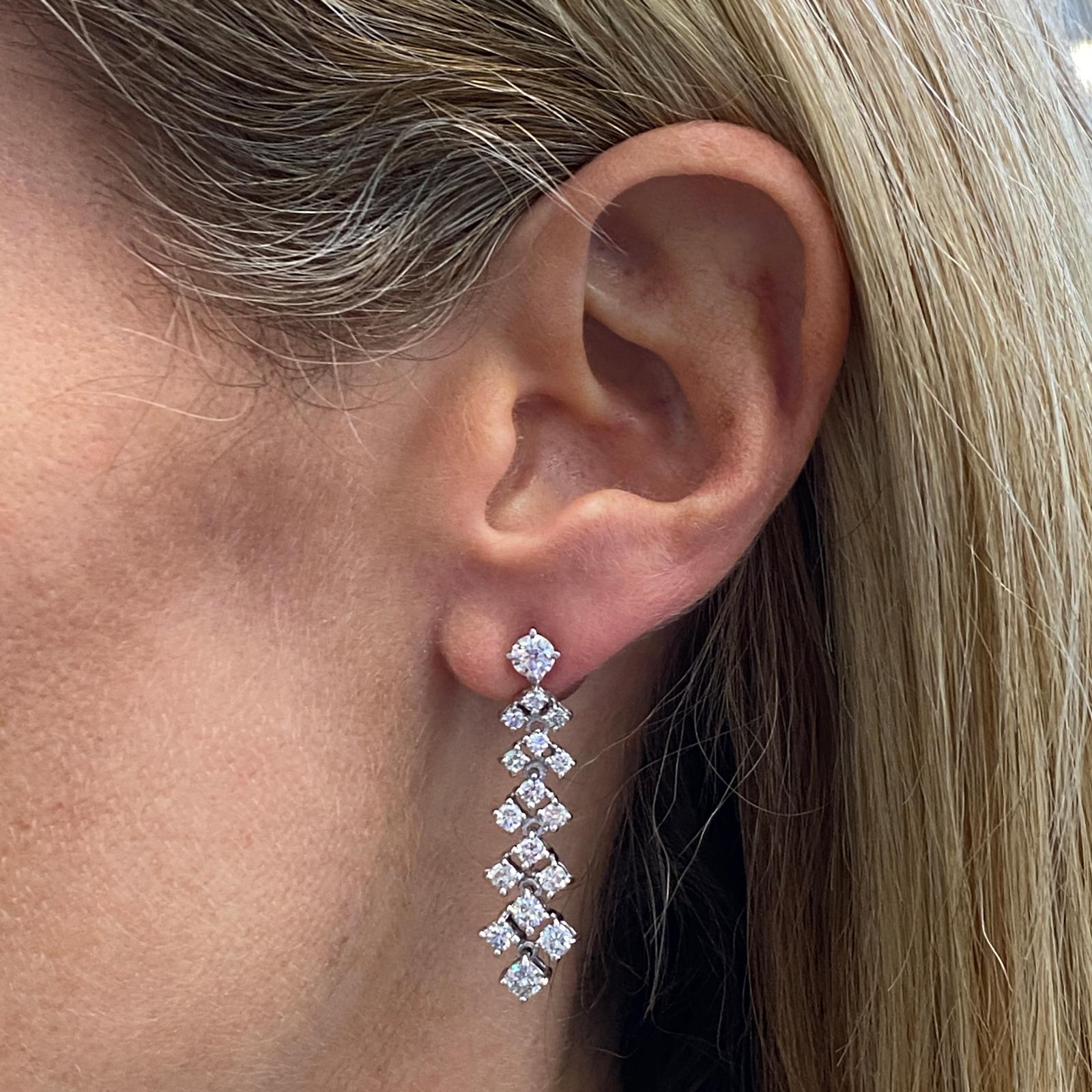 Beautiful diamond drop earrings fashioned in 14 karat white gold. The earrings feature 36 round brilliant cut diamonds weighing 3.90 carat total weight and graded G-H color and SI clarity. The mobile dangle drops measure 1.5 inches in length. 
