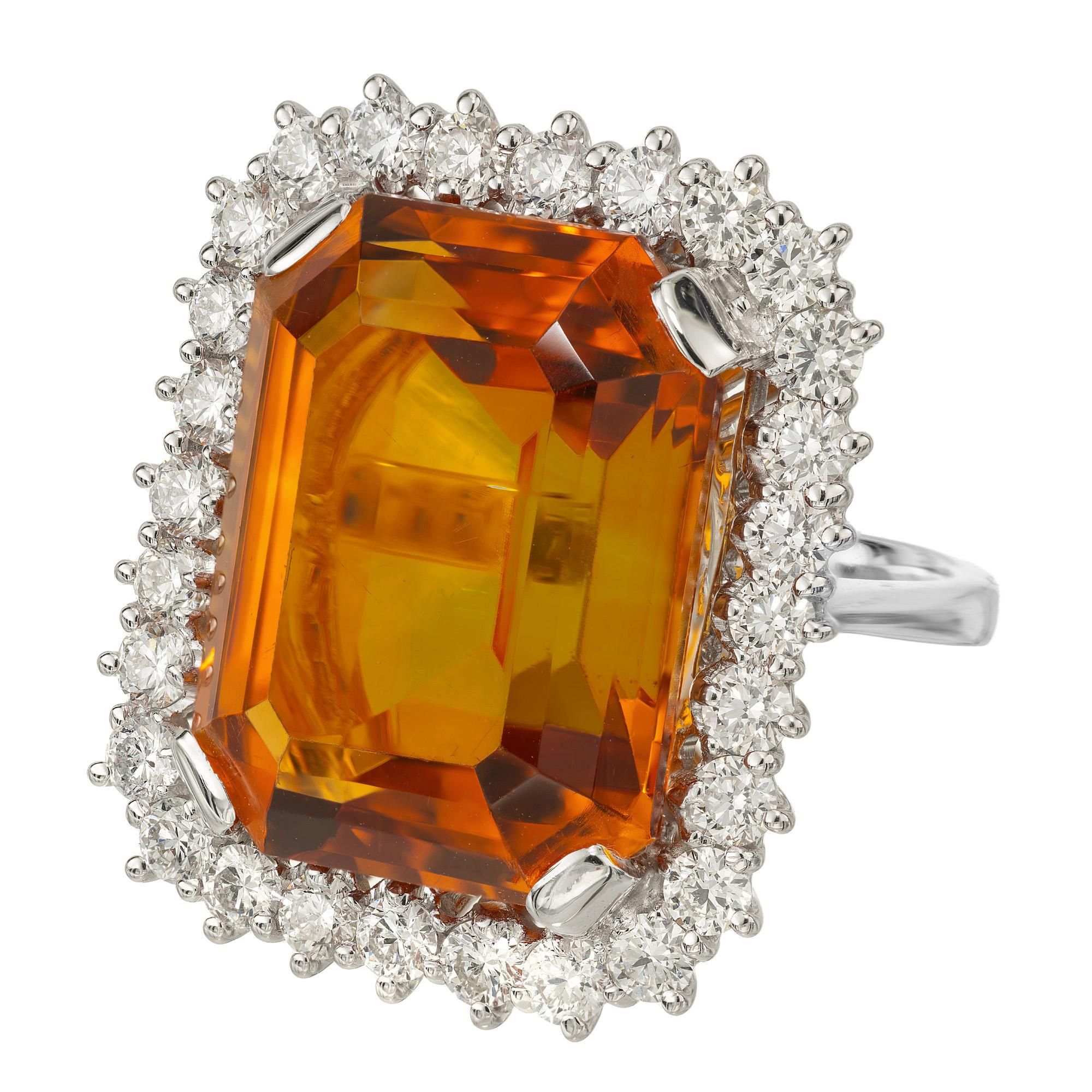Stunning orange rectangle citrine and diamond white gold cocktail ring. At the center of this captivating piece is a 39.00ct warm, rich orange citrine. Framed by a halo of 28 round brilliant cut diamonds in a 18k white gold setting. The epitome of