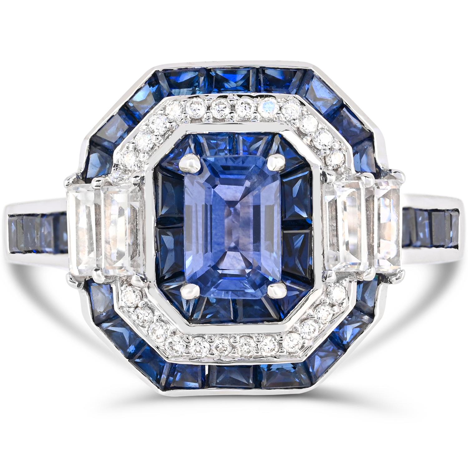 Inspired with Art Deco, this cocktail ring is an epitome of elegance.  This one-of-a-kind ring is set in 14K white gold and centered with 0.70 carat Emerald-cut Blue Sapphire, surrounded by glistening sparkly round brilliant-cut diamond accents and