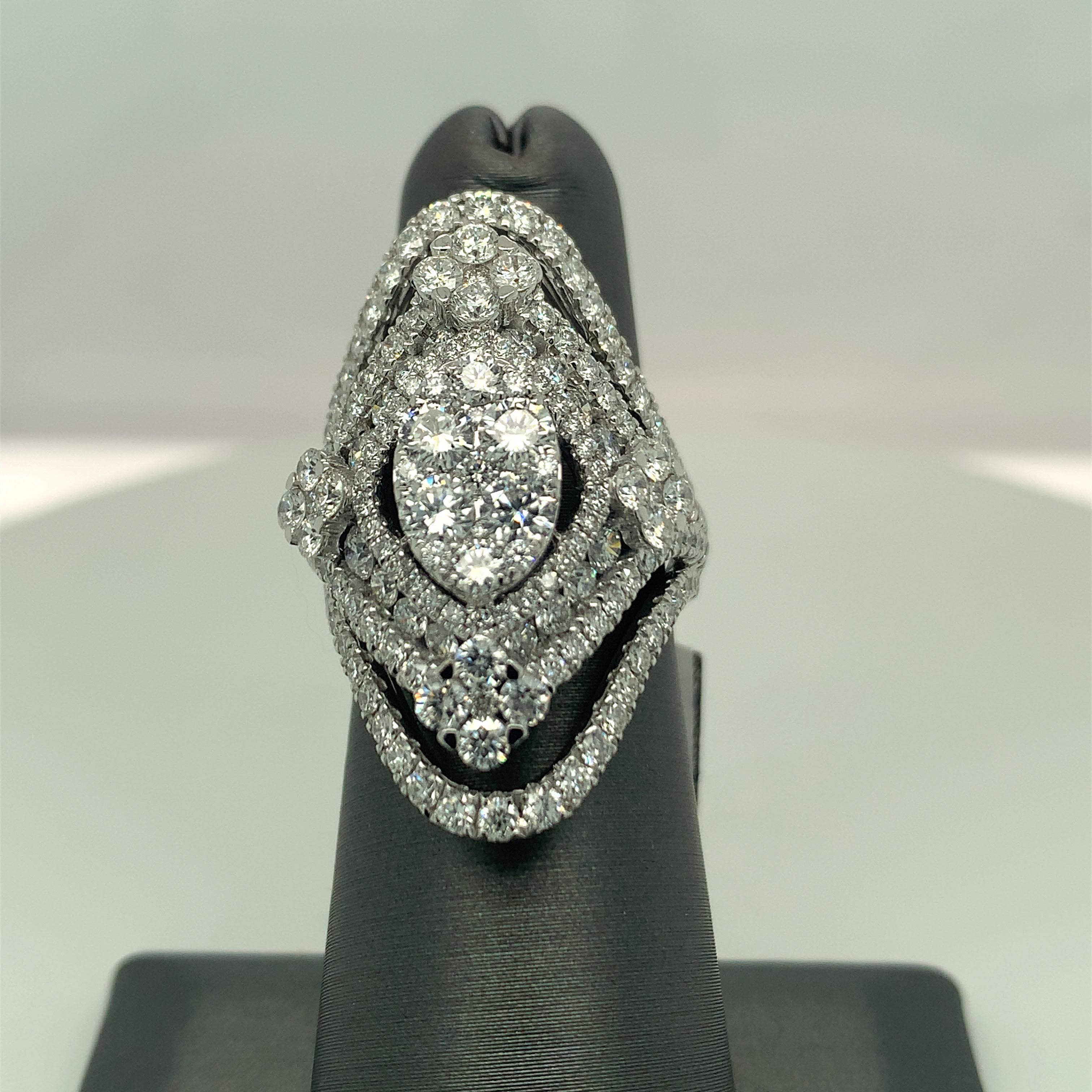 This exceptional creation of white diamond ring is one of a kind cocktail ring. Center oval platform of clustered diamonds gives an illusion of a solitaire center stone. 
Total Diamond: 3.91cts (179pcs)
Gold: 18K White ( 11gms)