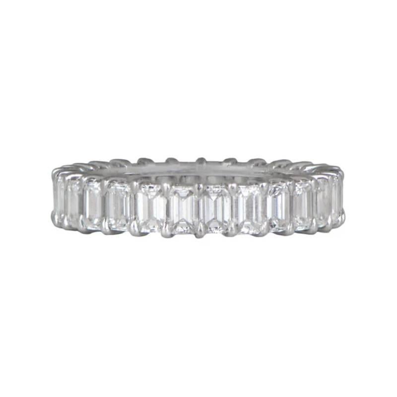 Indulge in luxury with this hand-crafted platinum eternity band showcasing emerald-cut diamonds set in shared prongs. The band boasts a total diamond weight of 3.92 carats, with H color and VS1 clarity. Its elegant design and 3.7mm width make it a