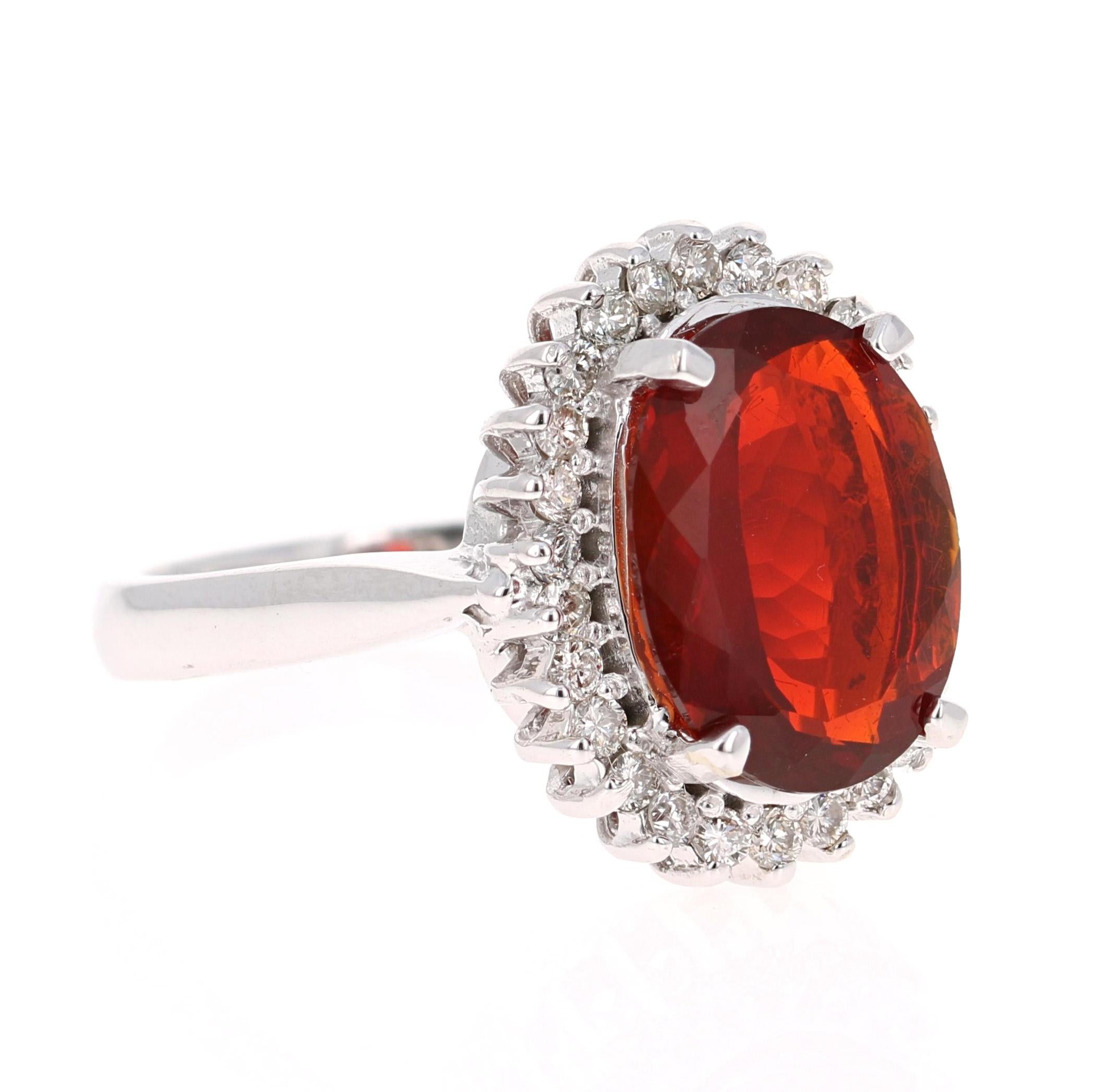 The Fire Opal is 3.35 Carats and is surrounded by 26 Round Cut Diamonds that weigh 0.59 Carats. (Clarity: VS, Color: H)

It is set in 14K White Gold and is approximately 7.7 grams. 

The ring size is 7 3/4 and can be re-sized at no additional