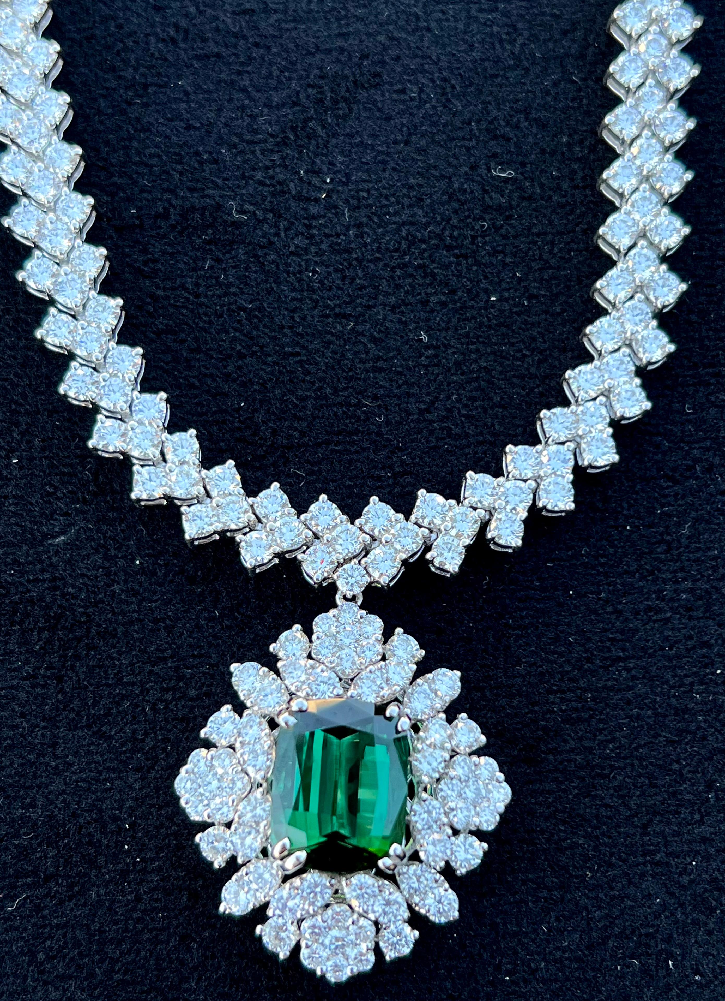 Very elegant, ladies estate 18 karat white gold, custom made 39.42 carat total weight pendant necklace features a rich 5.64 carat emerald cut natural green tourmaline in the center, flanked with an array of sparkling white diamonds in a diamond