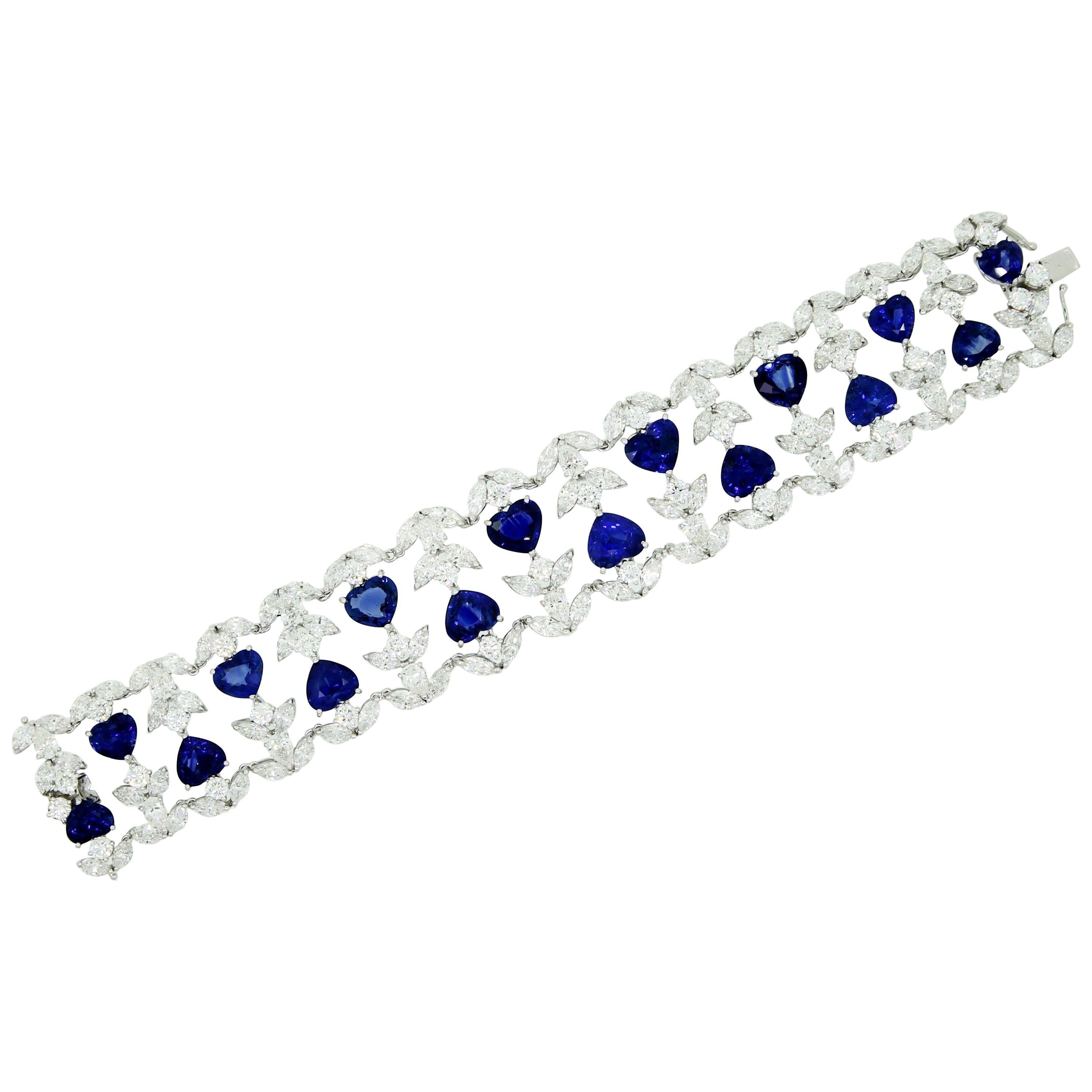 Such classical Colour Combination as Blue and White will never end.
In this sophisticated and Romantic Hand-Made Cuff Bracelet, 16 Heart Shape Blue Sapphires, for 39.45 Carata total, are framed by 146 White Pear and Marquise Diamonds, for 29.67