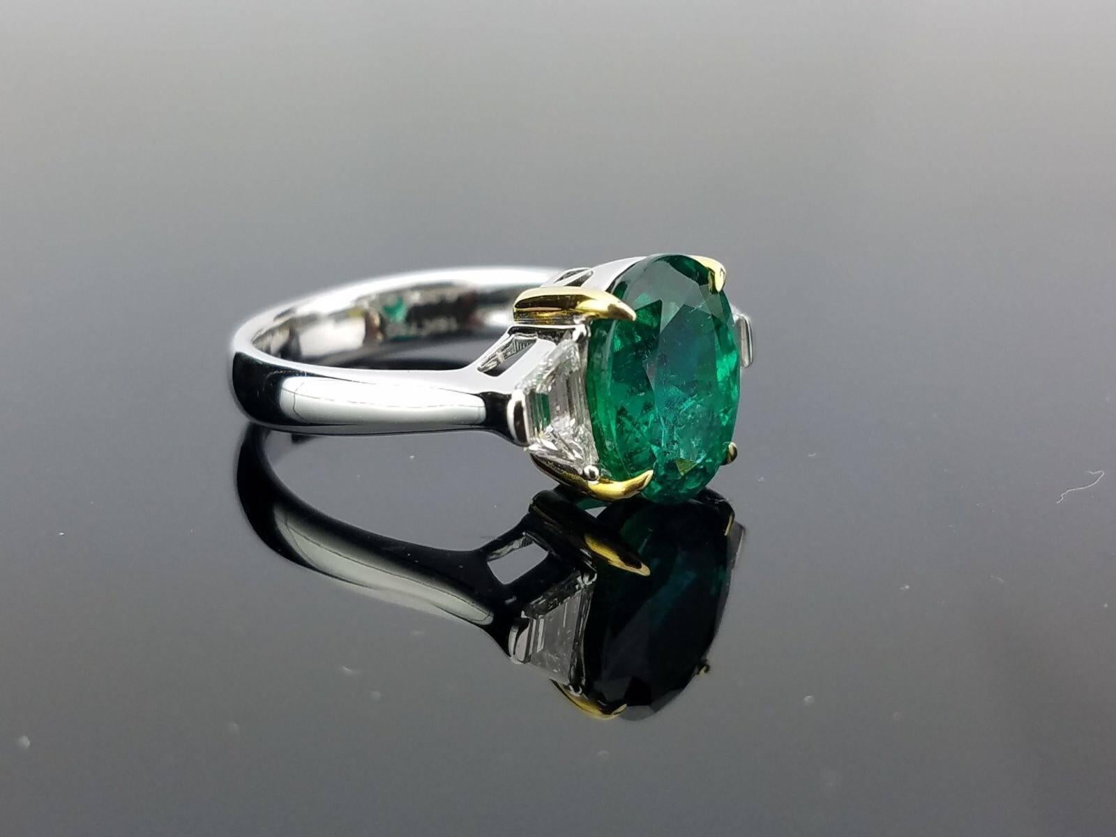 A classic three stone ring, with a 3.95-carat high quality and great colour Zambian Emerald centre stone and 2 trapeze side stone diamonds. 

Stone Details: 
Stone: Emerald
Carat Weight: 3.95 Carats

Diamond Details: 
Total Carat Weight: 0.39