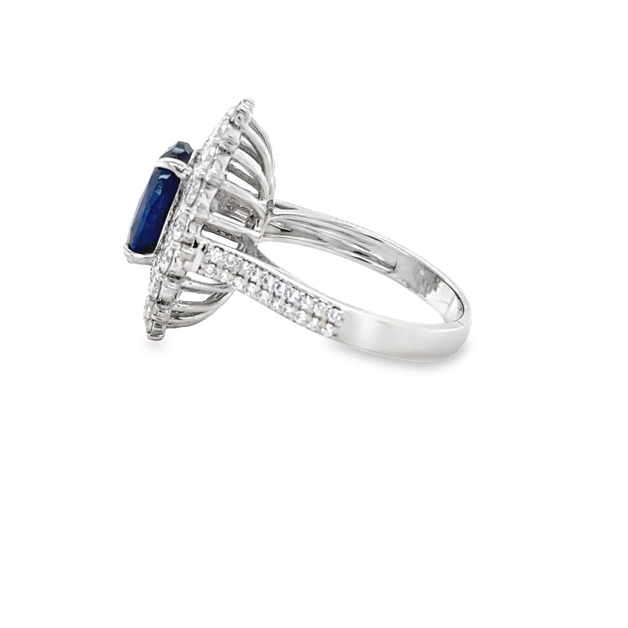 This gorgeous Sapphire cluster ring is set with a royal blue oval sapphire weighing 3.95ct , with open back setting. 
The gemstone is perfectly set in the centre of a beautiful cluster of over 100 round shaped diamonds weighing an approximate total