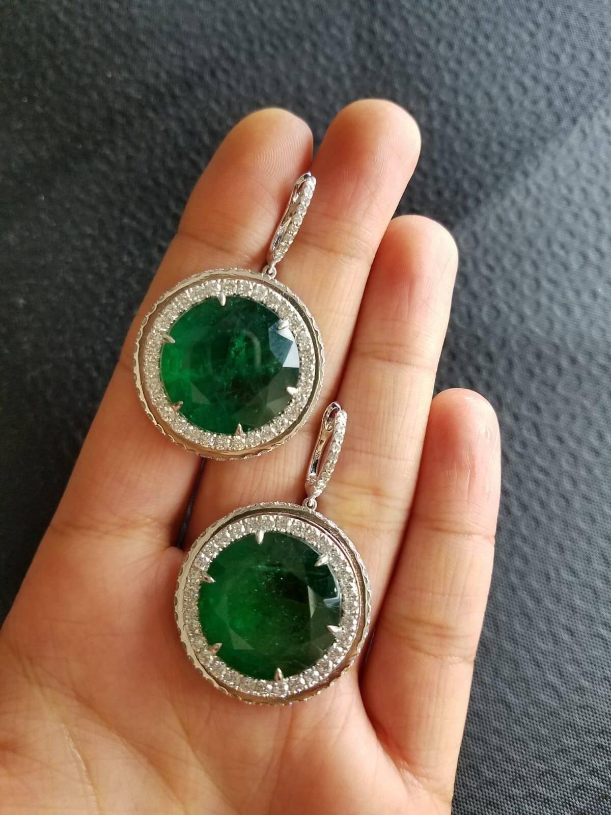 A very unique pair of statement dangling earrings, using high-quality round-shape (rare to find) Zambian Emeralds and Diamonds, all set in 18K white gold. 

Material Details:

Stone: Zambian Emerald
Weight: 39.53 carats
Shape:
