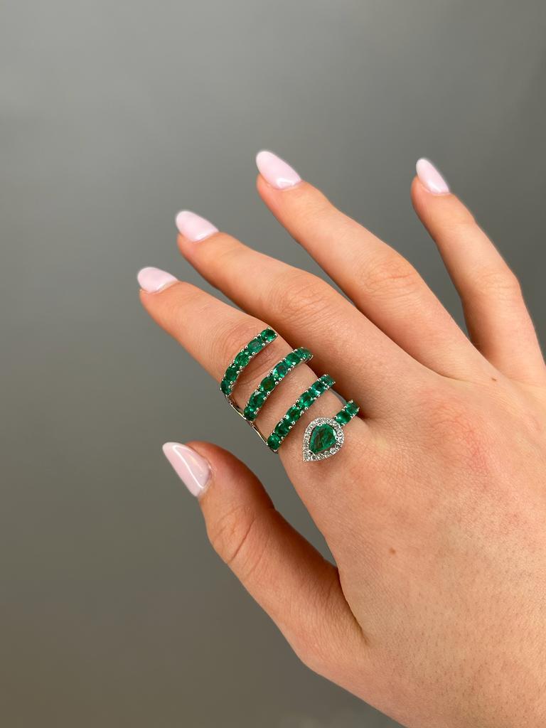This beautiful ring frames 3.51ct in emeralds and 0.18ct t.w. diamonds. Set in 18K Yellow Gold.

18K Gold: 6.95gr
Diamonds: 0.18ct - 17 pieces 
Emeralds: 3.51ct -23 pieces
Dimension: 36mm x 21mm
Size: 6.5
Available in White Gold
With natural