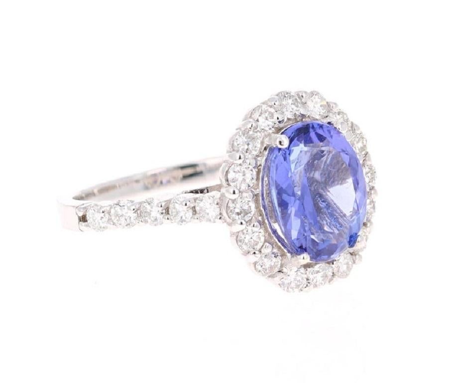 Dieser schöne Ring hat eine lebendige 2,93 Karat Oval Cut Tanzanite. Der Tansanit ist umgeben von 28 Diamanten im Rundschliff mit einem Gewicht von 1,03 Karat. (Reinheit: SI, Farbe: F)  Das Gesamtkaratgewicht des Rings beträgt 3,96 Karat.  

Der