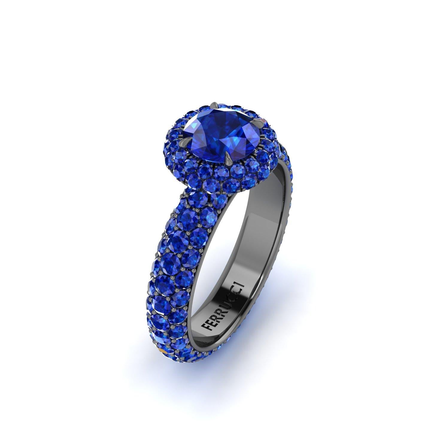 1.16 carat center Round Blue Sapphire set in a Double Round Sapphire Halo and a triple pave' set Sapphire shank eternity style ring, with a total of 132 Sapphires and an approximate total carat weight of 3.96 carats.

Entirely made in New York City