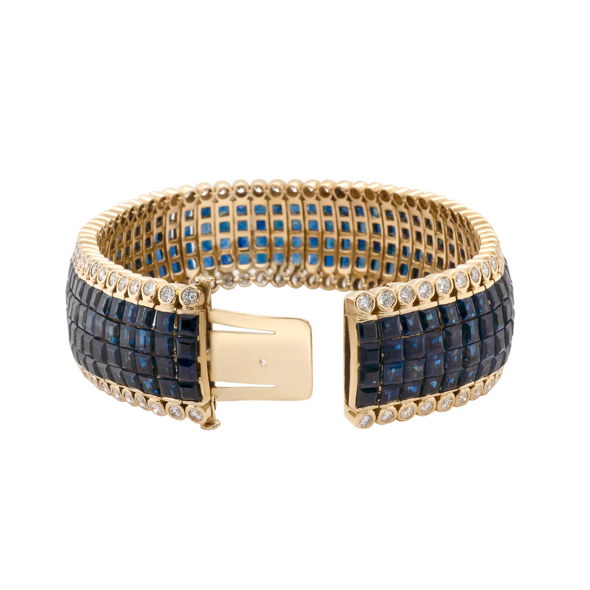 This invisible set blue sapphire bracelet is accented with round white diamonds along the sides. Set in 18k yellow gold, this piece boasts a total of 248 small square cut blue sapphires in four rows of invisible setting and 124 bezel set