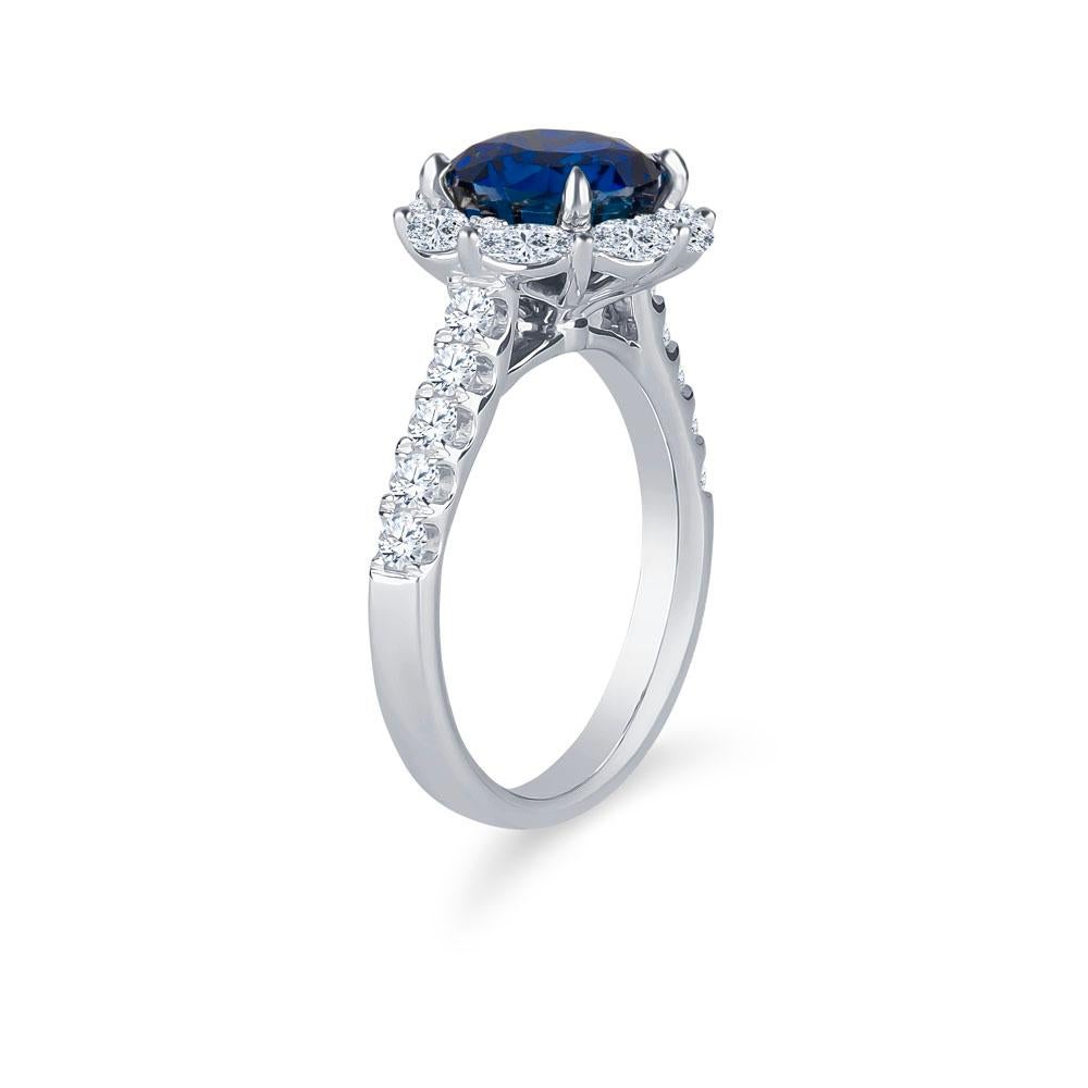 3.97 Carat round natural blue sapphire set in a 18k white gold diamond halo ring. 0.61 carats total weight of shared prong-set marquise diamonds in halo and 0.43 carats total weight of round brilliant split prong set diamonds halfway down the shank.