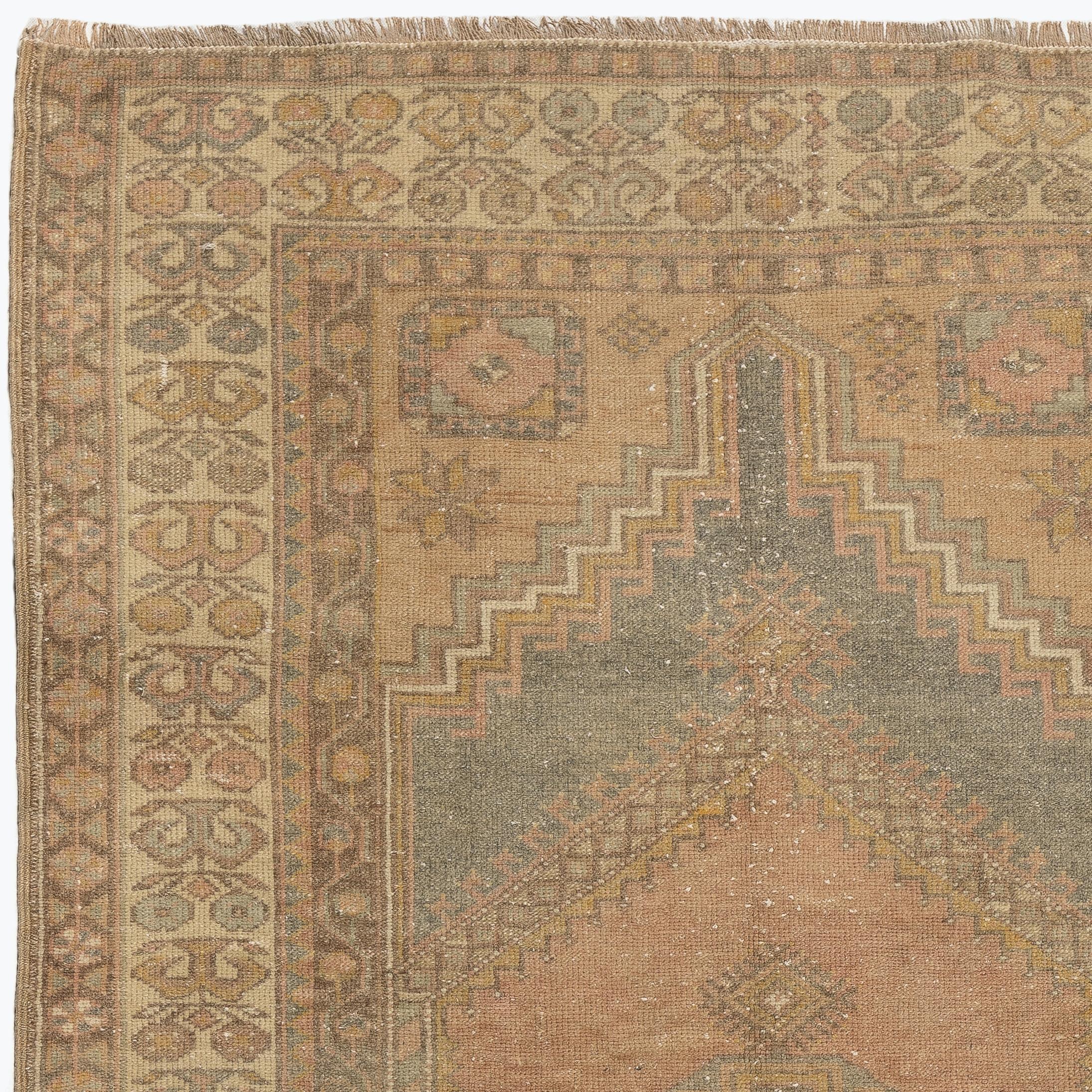 A finely hand knotted vintage Turkish carpet from 1950s featuring a geometric medallion design. The rug has even low wool pile on cotton foundation. It is heavy and lays flat on the floor, in very good condition with no issues. It has been washed