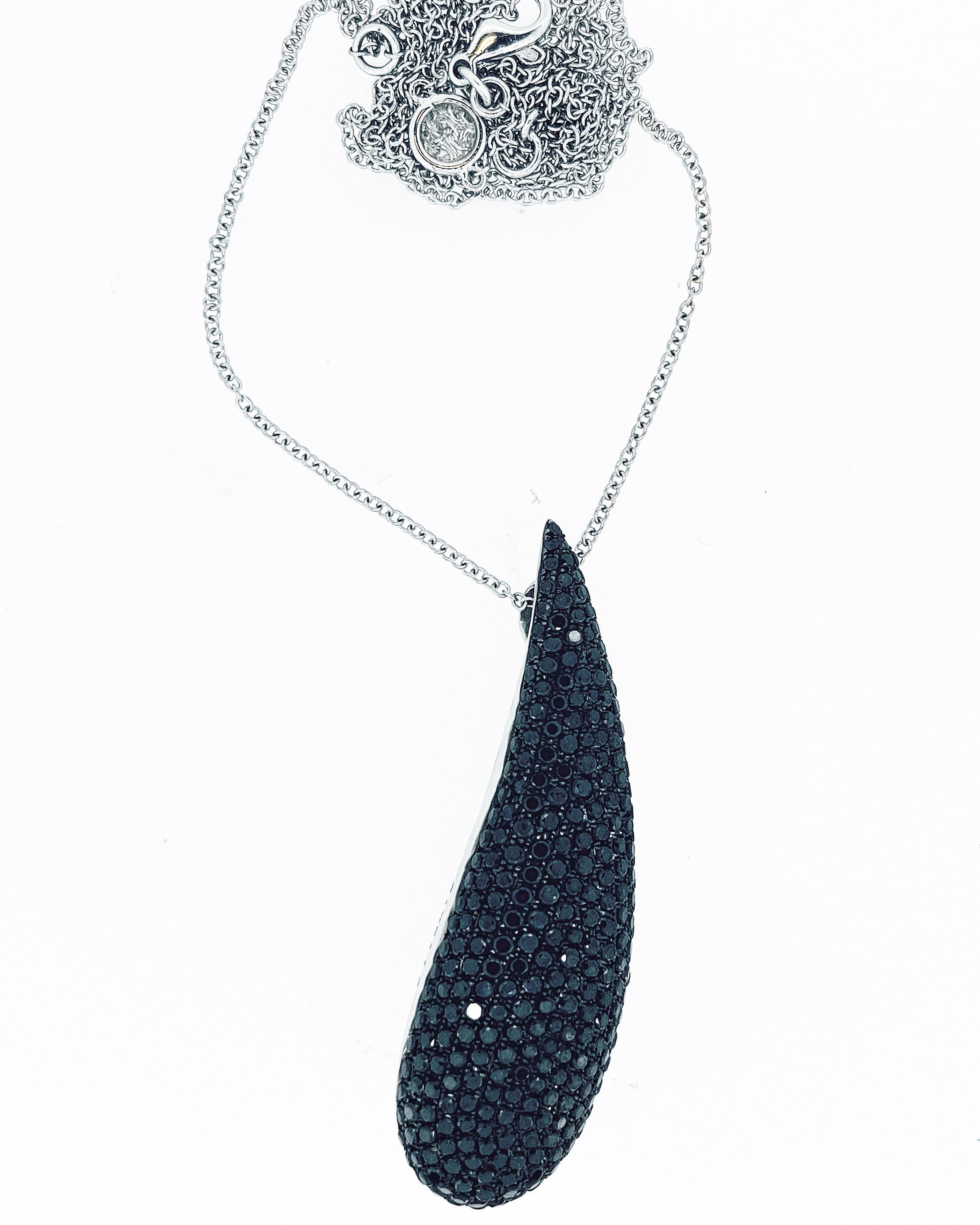 Gavello tear drop shape pendant pave’ set with black diamonds of appropriately 3ct. The 18ct white gold trace chain 80cm long set with a spectacle set rose cut diamond measuring 5mm. Weight: 24.1 Grammes. Circa 1990. Pendant measurements: 5.8cm x